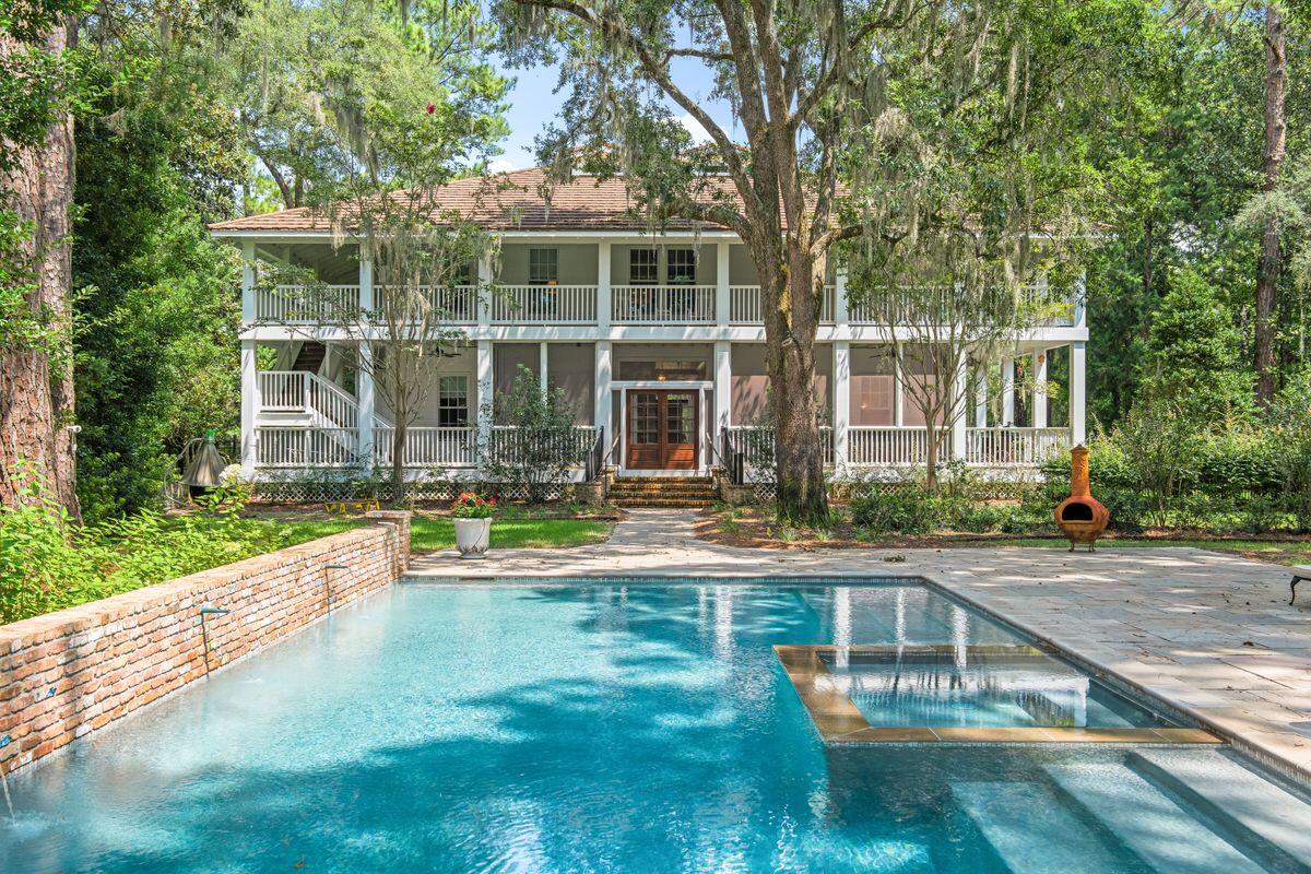 This fully restored Southern-style home is perfect for those who appreciate it's history and heritage. The home sits on more than an acre of lush private gardens featuring giant Southern magnolia trees, mature live oaks, long-leaf pines and other native trees. The lush private backyard with sandstone walkway features a welcome modern addition; a private heated, lighted pool with a copper fountain water feature and antique Chicago brick backsplash. Deep wraparound porches on both levels provide shady outdoor living space overlooking the peaceful natural surroundings.