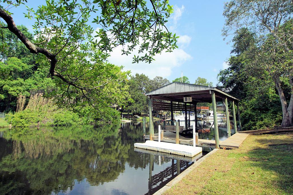 ATTENTION BOATING ENTHUSIASTS, 80' OF PROTECTED DEEP WATER IN THE HEART OF NICEVILLE!! Sailboats and cruisers will be protected in the deep-water canal leading to Rocky Bayou that is 6-9' deep and around 90' wide. The boathouse w/lift will accommodate up to a 23' boat and the dock can moor up to a 34' sailboat. The large rear yard (.36 acre lot) with a peaceful view across the canal is protected by a seawall and has mature oaks and magnolias providing cooling shade. This custom-built home with a NEW 2020 roof has an open floorplan with hardwood and tile floors throughout the downstairs. The large tiled great room is accented by a propane gas fireplace and a warm pine tongue and groove ceiling. The kitchen has a convenient center island, custom cherry cabinets, NEW granite counters, accent ighting and a Thermadore vent hood with heat lamps. The oversized utility room off of the kitchen has a laundry sink and can also be used as an office. The family room (expanded in 2009) overlooking the canal has hardwood floors, double doors to the rear deck and an abundance of large windows capturing the serene views of the canal. The master bedroom suite with a private bath, the 2nd bedroom and another full bathroom are downstairs. The oversized third bedroom is upstairs and this bedroom would also be a great office or exercise room. All of the bedrooms have large closets and there is eve storage accessible from the 3rd bedroom. This home is built with 2x6 cross braced rafters for the roof and is very energy efficient with insulated, internal HVAC vents (HVAC replaced 2019), solid interior doors, Peachtree windows, a newer water heater (2018) and a new roof installed February 2020. Exterior features include a large 30'x6' front porch, a 17'x15' deck in the rear, a circular driveway and a sprinkler system on a separate meter (can't do that anymore!). There is room to expand this home and protected deep water is a rare find so bring your boat and live your dream on the water in the heard of Niceville. Please note: Seller is also the listing agent.