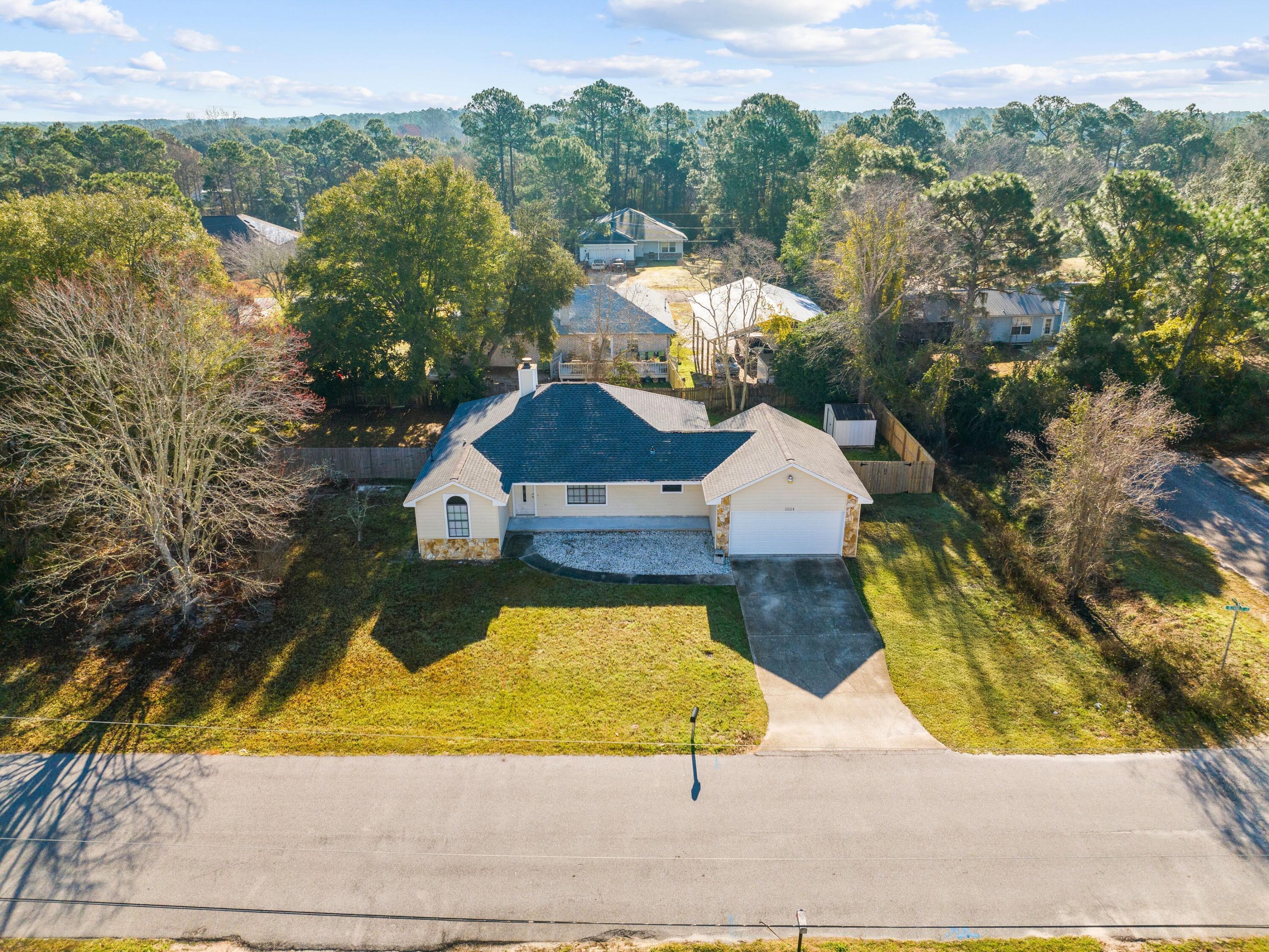 This charming home in East Bay River Estates offers a perfect combination of space, comfort and convenience. Featuring an open-concept design with a split-bedroom floor plan, the layout provides both functionality and privacy. The living room is a welcoming space with vaulted ceilings, luxury vinyl plank flooring and a cozy wood-burning fireplace, making it an ideal gathering place. The kitchen boasts ample counter space and cabinet storage, ensuring plenty of room for cooking and entertaining. The primary suite is generously sized to accommodate a king-sized bed, with an ensuite bath that includes a cedar-lined walk-in closet. A bright Florida room off the dining area offers the flexibility to be used as a playroom, office or additional sitting area. Situated on a .33-acre lot, the backyard is fully fenced with plenty of space for a pool, pets or outdoor activities. A deck provides the perfect spot for morning coffee or afternoon grilling. Recent updates, including a three-year-old roof and a brand-new HVAC system, add to the home's appeal and efficiency.
Located just 15 minutes from the back gate of Hurlburt Field and the pristine shores of Navarre Beach, this property offers easy access to military bases, coastal recreation and local conveniences. With no HOA and a large yard, this home is an excellent choice for first-time buyers, military families or those looking to retire in a peaceful setting near the beach.