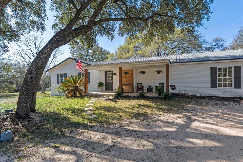 Professional photos coming soon. Charming farmhouse living on 4.05 acres! This 4BR/2BA home overs over 2,400 SF of space, including a sun-filled Florida room. Inside, the kitchen and baths have been tastefully updated while maintaining the warm country character that makes this home special.Recent improvements provide peace of mind: HVAC (2022), septic (2022), water heater (2020), and metal roof (2005).The acreage is full of possibilities-grapevines, walnut trees, and blueberry bushes already thrive here, while a mix of open land and shaded woods gives plenty of room to garden, raise animals, or simply relax. An outbuilding with covered space offers storage or hobby use and conveys as-is. Located in North Crestview with easy access to schools, shopping, and local bases, this home is also less than 45 minutes from Destin's white-sand beaches and under 30 minutes to Kings Lake and Rocky Bayou. A true blend of country charm and coastal convenience-don't miss out!