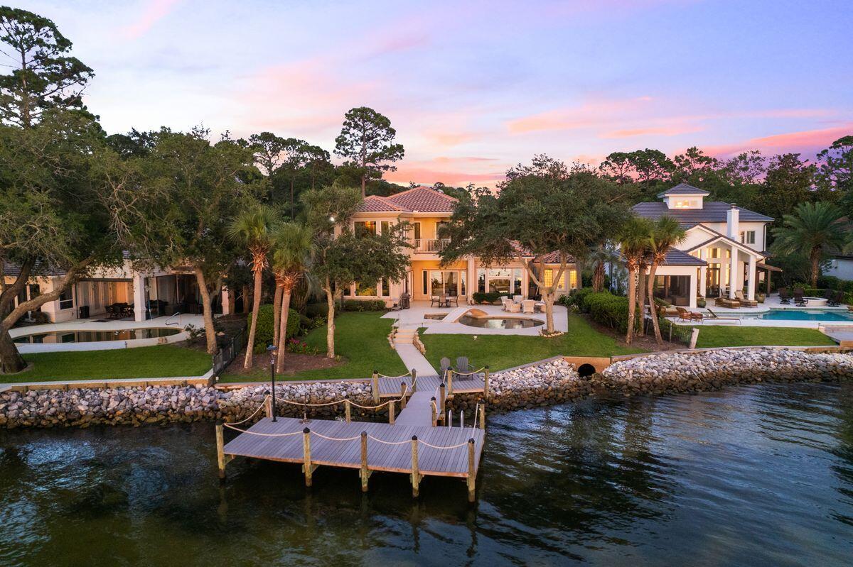 This outstanding bayfront estate is the ideal permanent residence or second home for those who enjoy boating, water sports and sunset vistas. Packed with wonderful design features, it has many luxury amenities including an elevator, remote screens, Lutron lighting and a private Trex dock. The sweeping paved driveway leads to the upgraded garage, golf-cart garage and covered porch entrance. Step inside to admire the expansive open-plan living area with exquisite travertine flooring and streamlined decor. It provides a fresh sunlit space for entertaining, relaxing and enjoying life to the fullest. Doors and windows frame tempting views of the elegant pool, terrace and tranquil bay waters from multiple sitting areas. An eye-catching helix staircase winds upward to the second floor, if you