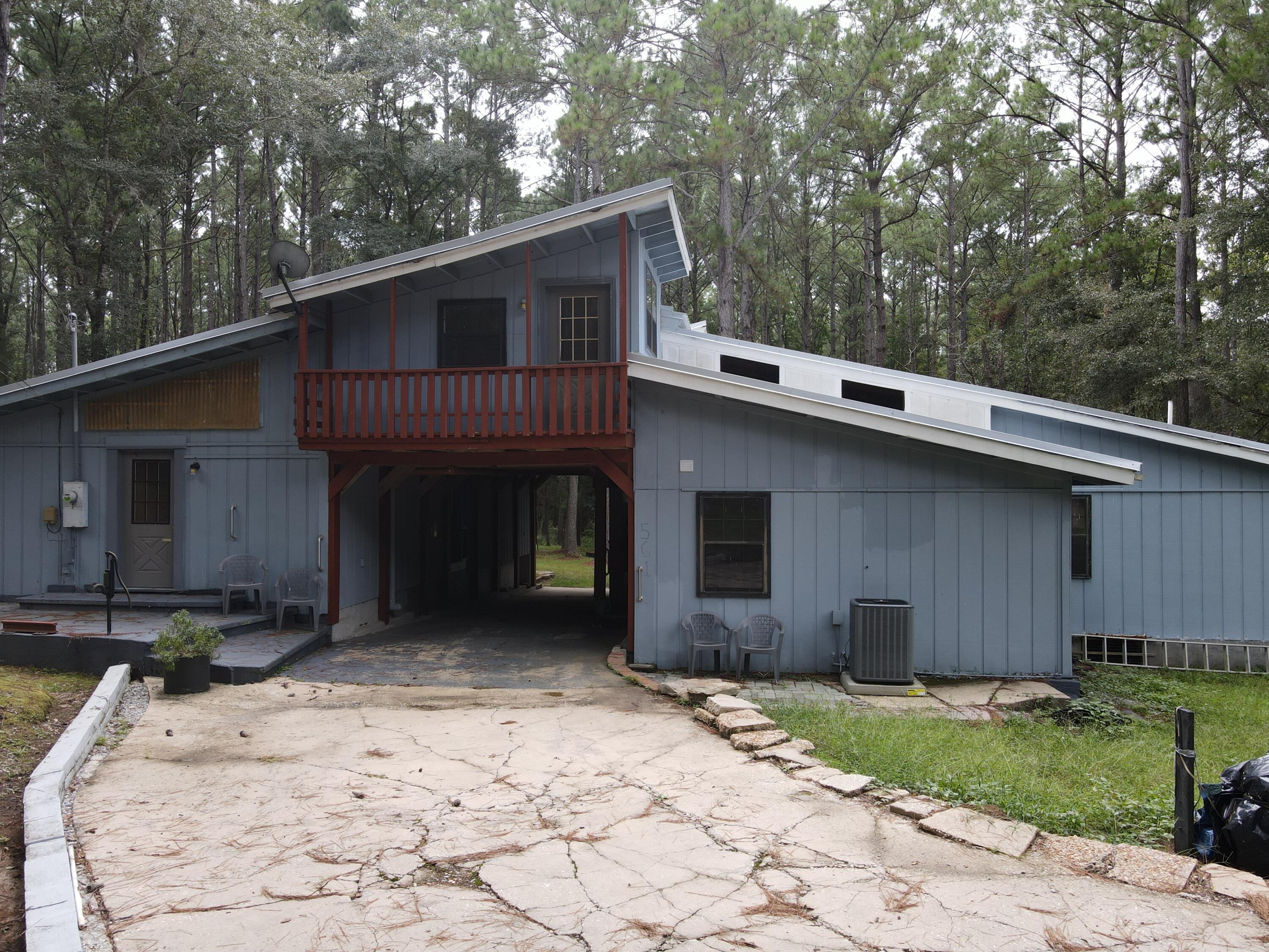 Nestled in the heart of Walton County, Florida, this barn-style home is set on 65 picturesque acres of unspoiled natural beauty. Surrounded by towering old-growth pines and majestic hardwoods, the property offers a serene retreat into nature. The landscape is adorned with sandy-bottom creeks that meander through the land, entering from three distinct points and gracefully converging before flowing southward toward DeFuniak Springs.The home itself exudes rustic charm with its barn-inspired architecture. The exterior features a classic metal roof with a center pass through for catching the breeze or staying dry during the typical North Florida afternoon shower.  The home features three bedrooms and one bath upstairs, spacious kitchen, living room and two bathrooms downstairs