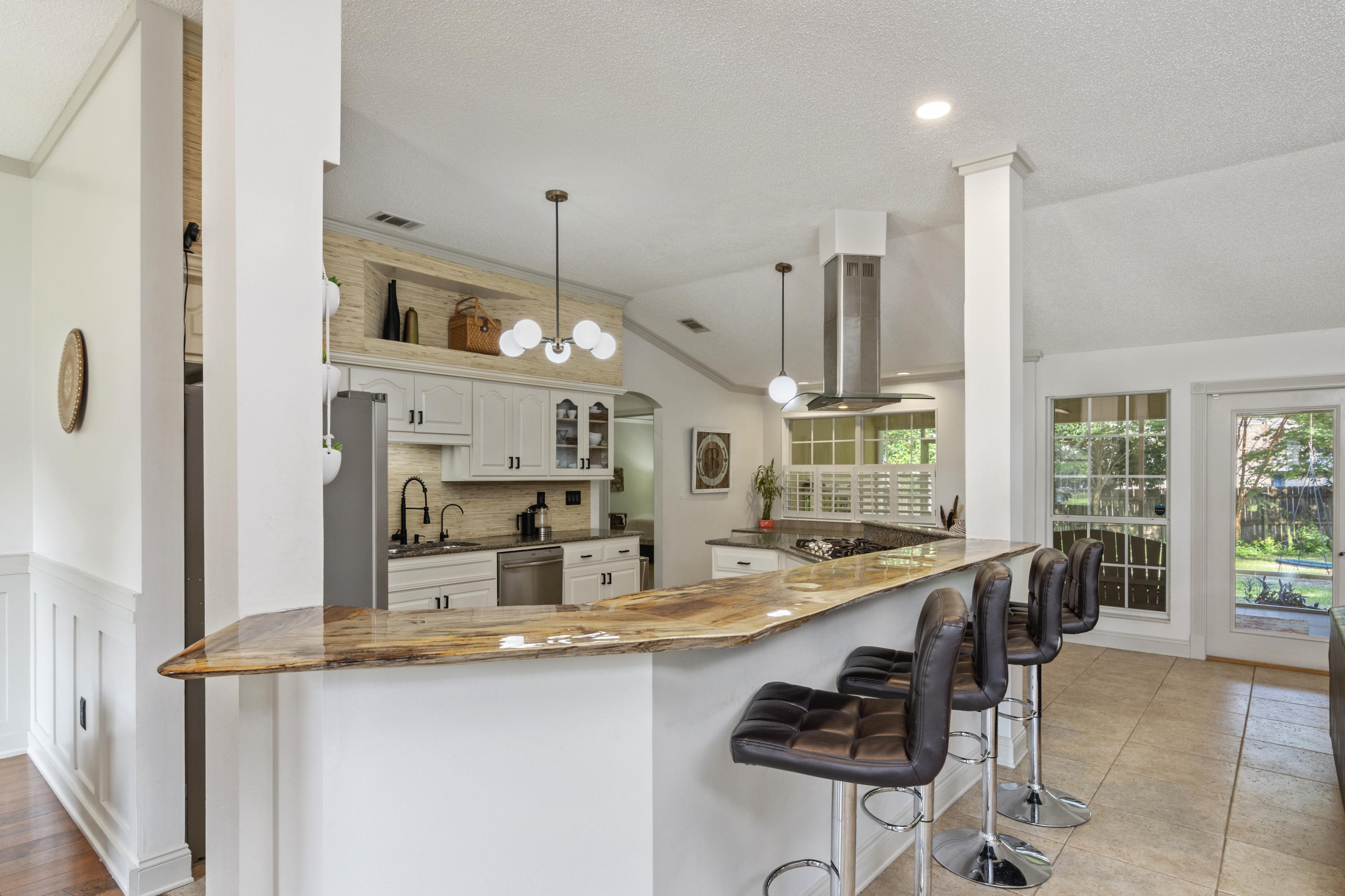 Located along a cul-de-sac in THE ideal neighborhood in Crestview for access to all the bases: this custom home has one of a kind updates, a huge workshop, and a fenced in backyard wonderland for kids! As you step into the home, you'll immediately notice the stunning 12ft live-edge poplar bar top that was added in place of a wall to open up the entire kitchen, living, and dining space. With the 10ft ceilings and windows all along the back wall, the space feels enormous. In the kitchen, you'll find an extra large 5-burner gas stove top and hood, tons of cabinet space, bar top space for 6, a separate desk area, and updated sink and cabinet hardware. In the dining room, you'll love the custom wainscoting and trim. The living room has a beautiful gas fireplace with a real cherry wood mantle. Just off the living room is a flex space that could be used as a 4th bedroom or office. The large master bedroom features a vaulted ceiling with space for a king bed and sitting area. Move on to the master bath to see the stunning vanity and new lighting, large closet, huge garden tub, shower, and access into the laundry room. On the other side of the house is a fully updated guest bath along with the two other spacious bedrooms. Through the back french doors, step down into the spacious 30x14 screened in back porch, and out into the back-yard oasis for kids and pets alike. Follow through one side-gate to access the storage shed or through the other side-gate to access the huge 20x24 fully insulated cooled workshop with garage door, 220 volt electrical, and it's own access from the street. With its own attic, this storage building has endless opportunities. This one of a kind house, in a beautiful established neighborhood with no HOA fees, and with plenty of storage opportunities on the very southern tip of town, makes it like no other. Bring the kids or grandkids, and come enjoy being only one stoplight from Destin!