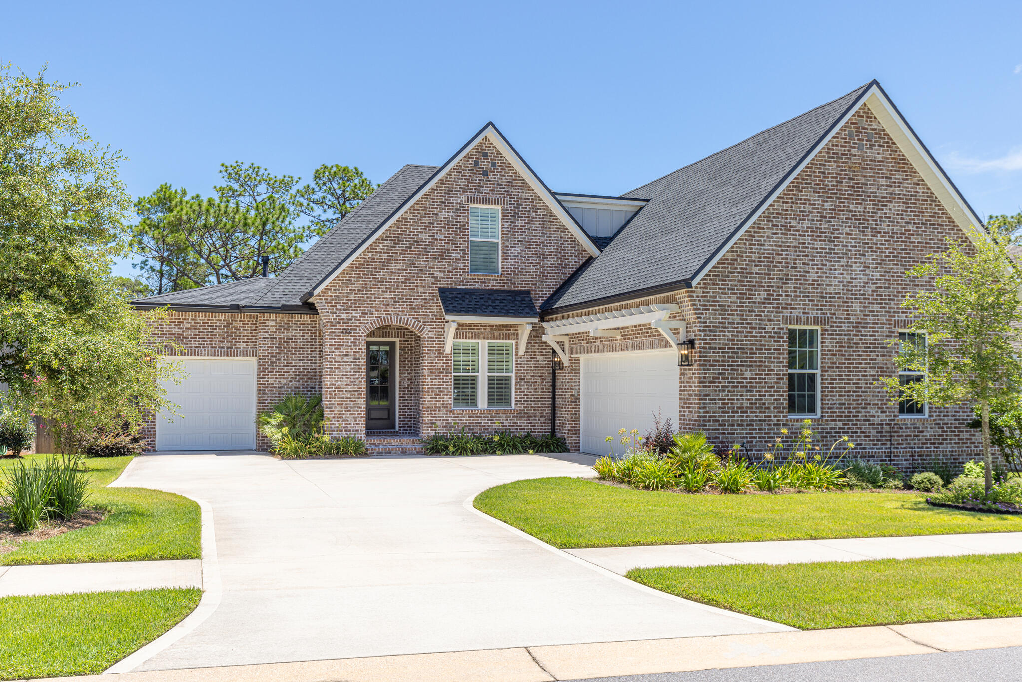 Experience the inviting lifestyle of Deer Moss Creek, a walkable community known for its scenic nature trails and neighborly charm. This all-brick custom Randy Wise home offers five bedrooms, a dedicated office off the foyer, and a peaceful wooded backyard that provides both space and connection. Eligible for VA loan assumption at a 5.75% interest rate for qualified buyers.Inspired by the sought-after Daphne floor plan, this home features thoughtful upgrades and exceptional craftsmanship throughout. Distinctive architectural curves and a covered entry create a welcoming first impression, leading into an open-concept layout that blends stylish design with practical living. A statement gas fireplace with custom built-ins anchors the living room, creating a seamless transition into the dining area and gourmet kitchen. The kitchen impresses with professional stainless steel appliances, custom cabinetry accented by lighting, a farmhouse sink, and a spacious walk-in pantry. A large island takes center stage, offering ample space for gatherings and meal prep.
Retreat to the first-floor primary suite, where an expanded bathroom with separate shower and tub invites relaxation. A generous walk-in closet connects directly to the laundry room for added convenience. Nearby, a guest bedroom with its own en suite provides comfortable accommodations, while a drop zone and epoxy-finished attached garage round out the main level.
Rich hickory hardwood flooring continues from the main level into the upstairs bonus area, a versatile space ideal for a home office, playroom, or media room. Three additional bedrooms and bathroom offer ample living space, including access to a large unfinished storage area perfect for seasonal items or future expansion.
Equipped with smart features, the home offers pre-wiring for surround sound and a security system, plus eight professionally mounted televisions throughout. A home generator adds an extra layer of reliability and ease.
Outside, the screened-in porch includes a summer kitchen with wood accents, and a ceiling fan, making grilling and entertaining effortless. The open deck leads to a large fenced backyard backed by woods and surrounded by nature trails. The generously sized lot is just a short walk from the community pool, basketball courts, and clubhouse. Don't miss this opportunity to live in Deer Moss Creek, a masterfully planned 1,100-acre community.