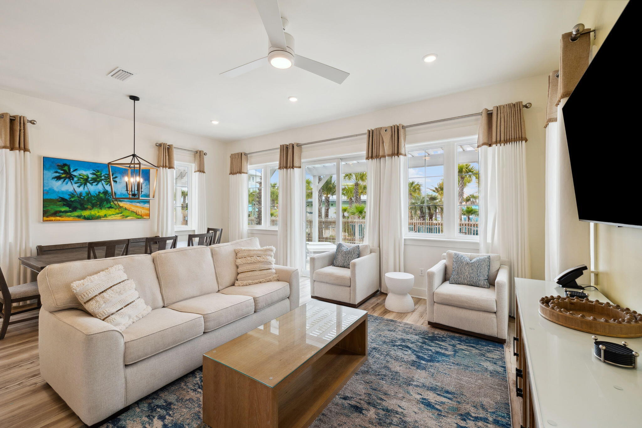 13649 Banana Wind Way is one of the most desirable homes in the coveted Margarittaville Cottages in Panama City Beach, Florida. This beautiful home is one of the premier lots in the subdivision with a world-class resort style pool & lazy river right outside your back door. The community also boasts 580 feet of private, dedicated sugar-white sand beaches. The subdivision has a newly constructed multi-level entertainment facility that includes an arcade, restaurant, fully equipped gym, and conference rooms. These new amenities create an ideal environment for vacation rentals by making Margaritaville Cottages a perfect place to host corporate retreats, family reunions, wedding parties, and other large groups. This poolside cottage is a 5 bedroom, 4.5 bath home that spans 2,128 heated and cooled square feet with an additional 350 square feet of covered outdoor space. The details of the home are ideal for a vacation rental property or for personal use with its white quartz countertops, grand island in the kitchen, tankless water heater, and stainless steel gas appliances. The luxury vinyl plank flooring is ideal for a poolside beach house with its chic look, durability, and water/pet resistant finish.
The open floor plan flows smoothly and maximizes the use of space throughout the home. The kitchen has a grand island with seating for four and an adjacent dining area with seating for eight people. It also has stainless steel appliances including a 36" gas range. The 10' ceilings throughout the first level make the home feel spacious, and the ample windows provide gorgeous natural lighting in addition to their views of the resort-style pool. The half bath off the main living area is perfect for guests, and the downstairs suite has its own ensuite bathroom with dual vanities and walk-in shower.
Upstairs, the quartz finishes are carried throughout the ensuite bathrooms attached to the bedrooms, and the luxury vinyl plank flooring on the first level is present throughout the upstairs as well. One detail I love is that they ran the tile all the way to the ceiling in every shower which gives them a classy touch, that's a detail that so often gets overlooked at this price point. Upstairs also has a washer and dryer that's smartly tucked away into a closet for a minimalist look, and its built-in shelving provides additional hidden storage.
Margaritaville Cottages is a premier subdivision in Panama City Beach, Florida located only 2 miles from the renowned Pier Park shopping center, and it also boasts world-class amenities such as a 425 ft lazy river, resort-style pool, two waterslides, a private beach, and brand new multi-level amenities center. The community also has an on-site rental manager and is backed by the Margaritaville brand which is recognized around the globe for its quality and coastal luxury lifestyle.