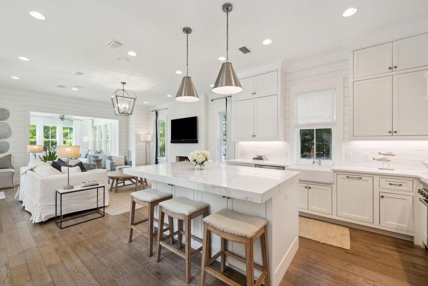 Just 100 yards from the white sandy beach, this showstopping home is brimming with bonus features. A private pool enhances the peaceful rear yard while a lofty west-facing lookout tower on the fourth floor provides panoramic views. It's a special space to watch sunsets over the iconic WaterSound rooftops lining the stunning Emerald coastline. Two full-width front porches provide quiet retreats for reading and relaxing in the shade. Cool white interiors create a light and airy ambiance in the inviting living room, which has deep-cushioned seating around the white brick fireplace. Wood flooring winds through the defined living spaces that include a formal dining area and a wet bar with a refrigerator for serving perfectly chilled drinks. The chef's kitchen wows with veined marble countertops and a host of Thermador appliances, including a double oven and a six-burner gas stove. An island bar with stools provides additional seating for guests when entertaining. Step into the adjoining screened lounge to enjoy some fresh sea air or head onto the pool terrace to catch some rays. It's an excellent spot for a poolside barbecue beneath the swaying palms. A top-of-the-line sound system provides your choice of background music through a new amplifier, and there's a handy outdoor shower for rinsing off. Five bedrooms and five-and-a-half baths allow family and guests to enjoy their own privacy and space. Two plush master suites include one on the first floor with stair-free access. The spa-like ensuite bathroom includes a beautiful walk-in shower, an oval roll-top garden tub and a dual marble vanity. An elegant staircase leads to another exquisite master suite and two king-size guest suites. Youngsters will revel in two sets of twin-over-twin bunks in their own den-like bedroom. They will also appreciate the third-floor game room with its oversized screen for non-stop movies. There's another wet bar for the ultimate movie nights. Outdoors, there's ample space for parking on the paved driveway, which leads to a charming detached garage. This coastal haven comes with all the luxury amenities that WaterSound is known for.  Multiple pools, a private fitness center, a dog park, miles of boardwalks and one mile of the beaches stunning gulf waters.
