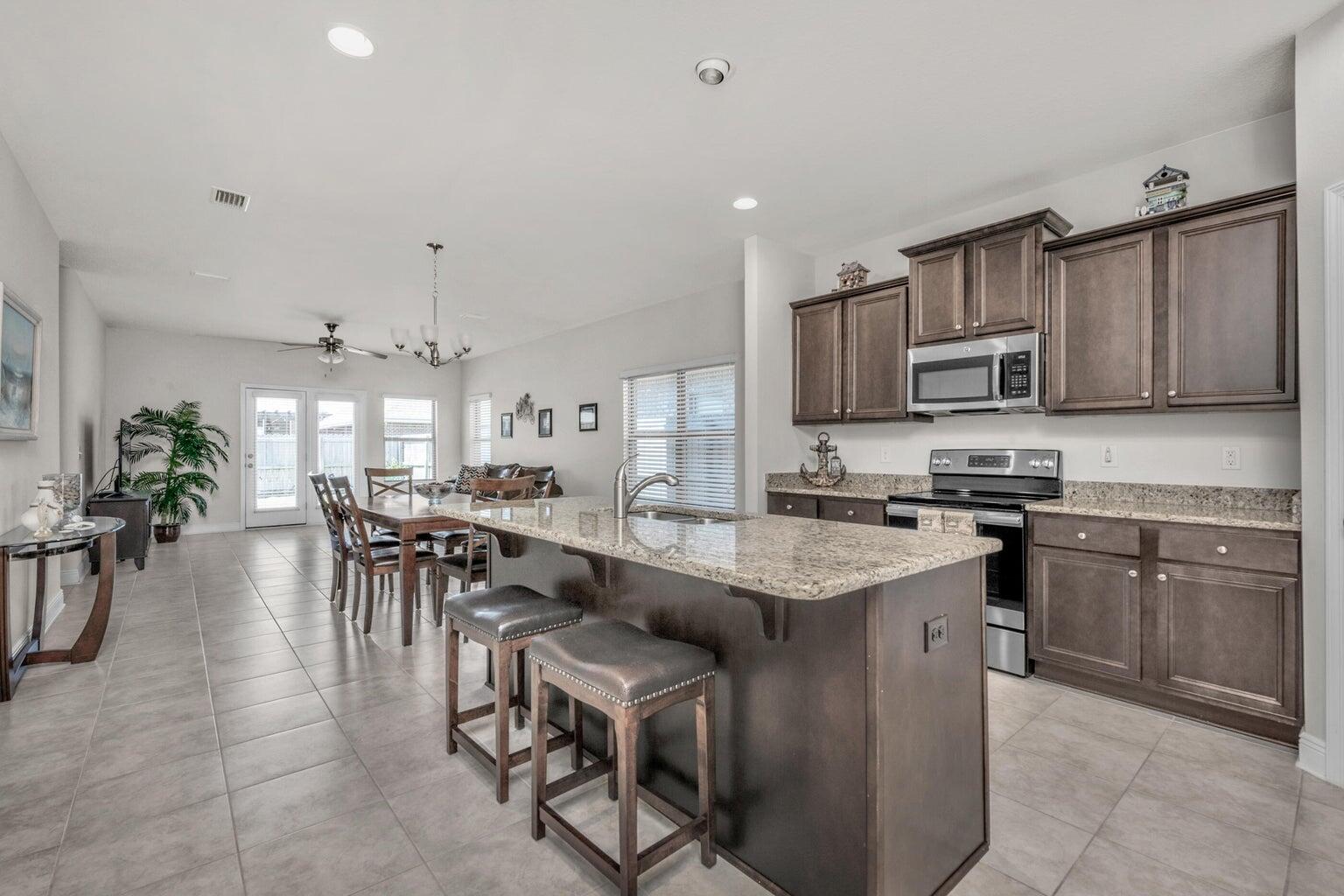 Immaculate, well maintained stunning 5-Bedroom, 2.5 Bath Home with Luxurious Features! Come home to this gorgeous 2-story home, boasting large spacious bedrooms and updated 2.5 baths. The lower level features elegant 18'' tile flooring throughout and a convenient half bath near the entryway. The neutral color palette provides a perfect backdrop for your personal touch. The kitchen is a chef's dream with granite countertops, stainless steel appliances, a coffee bar area, a large island with a sink, and beautiful cavalier espresso cabinets. The expansive pantry and breakfast bar offer ample space for storage and casual dining. Additional storage is available in the laundry room, complete with extra closet space. The master suite, located on the lower level, includes a luxurious master bath bath with a tiled shower extending from ceiling to floor, a garden tub, and high-level double vanities. French doors look, leads to the outside patio, creating an inviting space for outdoor entertainment and relaxation with a fenced backyard. Upstairs, you'll find a large additional living/den area, perfect for a game room or secondary family space. Two beautiful Archways lead to four more bedrooms, each equipped with walk-in closets and AC vents for added comfort. The upstairs full bath features double vanities for convenience, granite high level countertops, and tub/shower combination; This home also includes practical features such as gutters and more. Don't miss out on the opportunity to make this beautiful house your new home! Call for your private showing today!