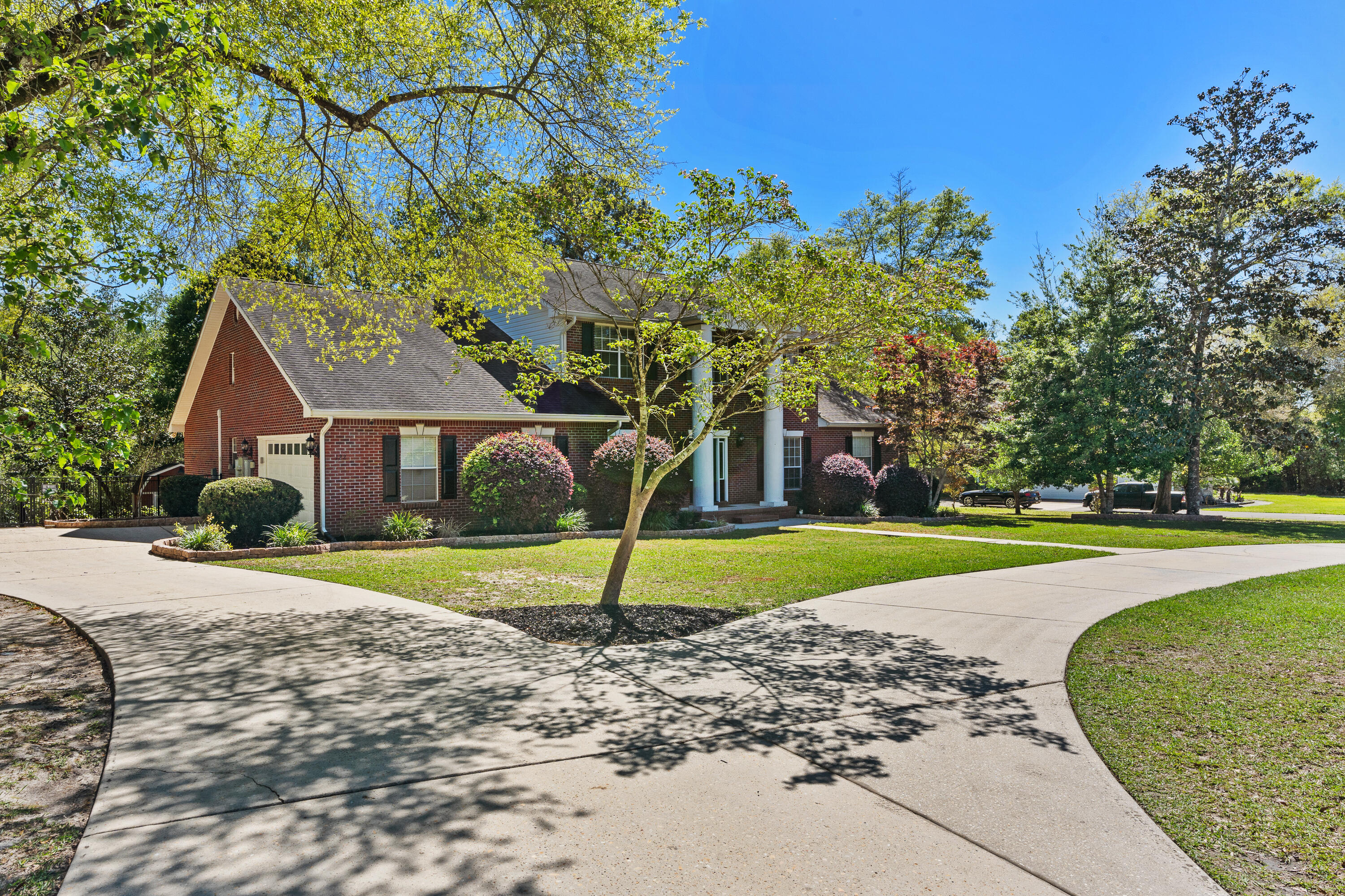 Beautiful colonial 5 bedroom 3 1/2 bath home located in the sought after Ashley Place subdivision in north Crestview. Pulling in the circle drive you will notice the stately columns and grand elevation. The newly installed wood look tile floors that cover the majority of the home are eye catching. Custom trim, custom raised panel wainscoting, and window casing are just some of the features that are immediately noticable. From the formal dining room to the back living room open to the kitchen you will right away envision entertaining friends and family with plenty of room to spare. The kitchen has been carefully updated with new cabinets, countertops, and back splash. The main living features a fireplace with updated top quaility insert and custom mantle. The secondary living room is a perfect family hang out spot with custom entertainment center with another high quality fireplace insert and a half bath. The formal dining room is stand out with custom trim features and storage. The Master retreat is downstairs and massive including plenty of room for oversized furniture, lots of closet space, and a spa like bathroom. Upstairs you will find three bedrooms with great closet space and two updated bathrooms. The attic has been customized with shelving for maximum storage and organization. The garage is currently set up as a craftsman's dream with shelving and space for woodworking. This home sits on one acre. Curb appeal is not lacking on this property. The front yard and circle drive are just beautiful. The back yard is fenced in but still allows views of the nature behind. Often deer come to the edge of the fence for a peek.