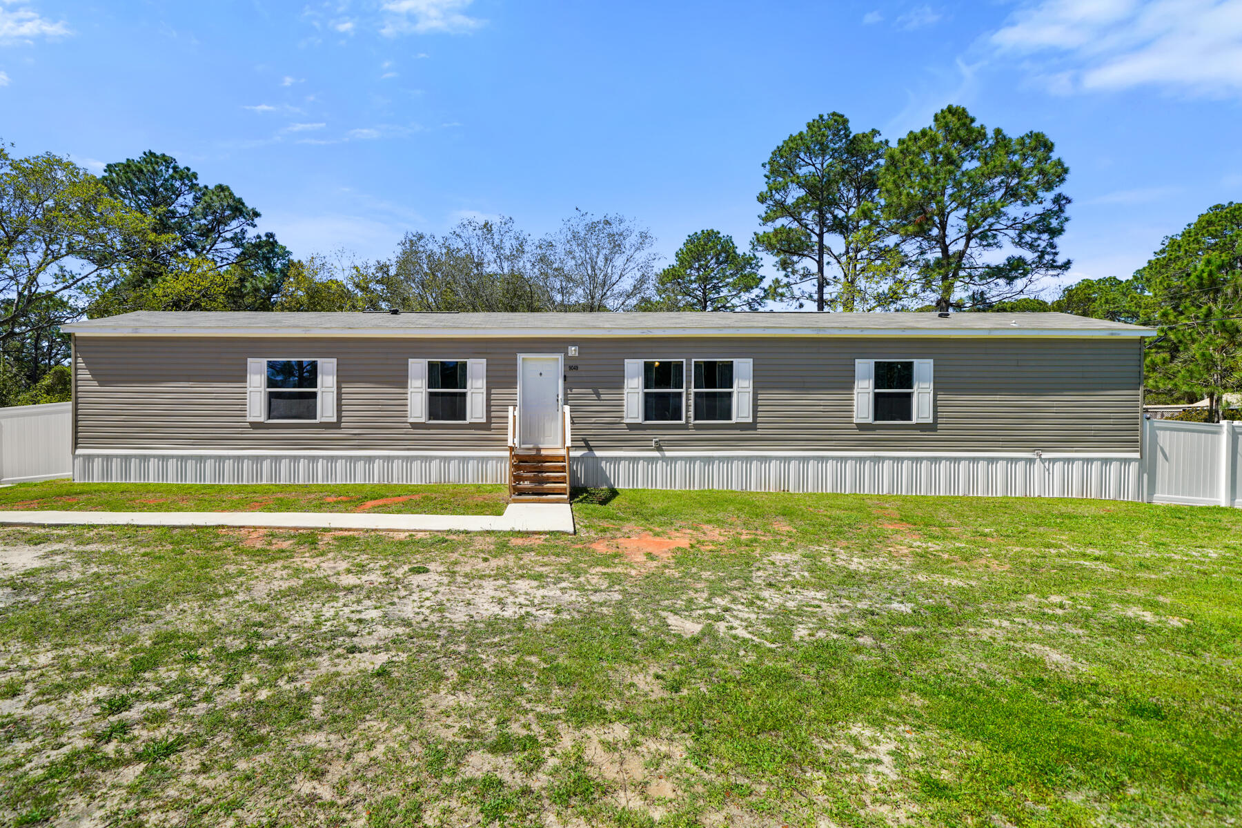 Welcome to 9049 Larker Trail in Navarre, where comfort, style, and investment opportunities converge! This exquisite property showcases a stunning mobile home from Freedom Homes, featuring the beloved Breeze model, all set on a generous, quarter-acre, fenced lot.Step inside to discover a spacious interior with an open-concept layout, seamlessly blending the living, dining, and kitchen areas. A perfect setting for hosting guests or enjoying quality family time. The kitchen is equipped with modern appliances and ample storage, catering to both culinary enthusiasts and those seeking quick, convenient meals, ideal for family and guests looking to experience coastal living.This haven also boasts a luxurious master suite, offering a double vanity sink,