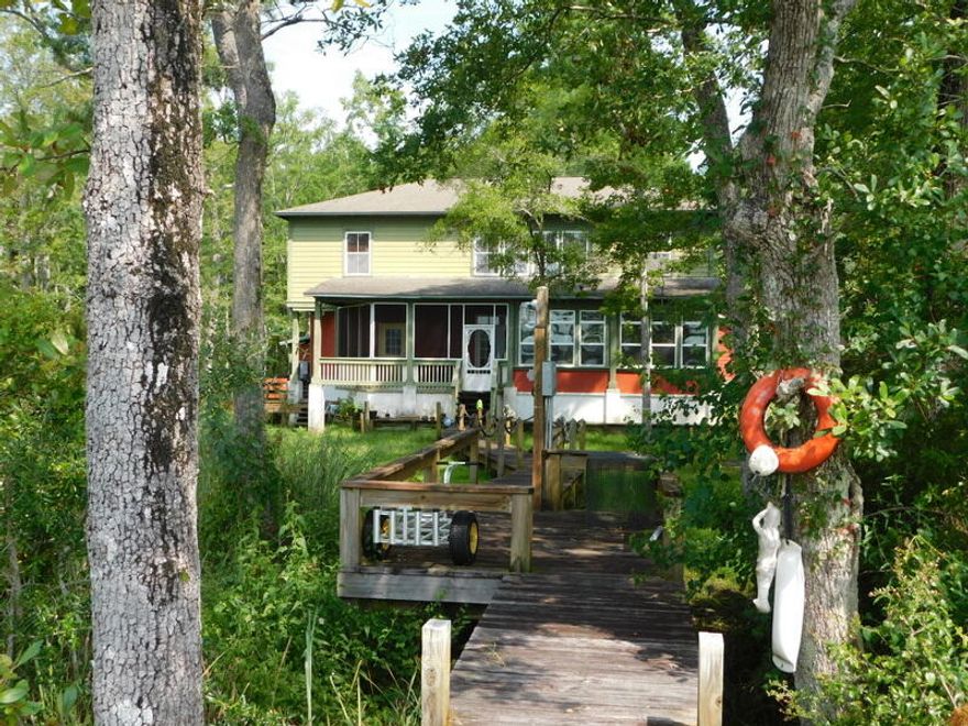 Here is your opportunity to own a true piece of Florida located on Lagrange Bayou  and minutes to shopping, beaches, I-10 and premier fishing &  golfing. This Florida cottage is nestled in the beauty of Live Oaks, a marsh preserve and peaceful walk on the boardwalk to your new 8,000 Lb.  boat lift and dock .If you enjoy beauty and nature, look no further. Inside, you will love the new kitchen, stainless steel appliances, granite, tile floors and an awesome bay view! There are two very nice master bedrooms upstairs and two bedrooms with their bathroom on the other side of home divided by a great room and again...awesome view! There is a dining area/sitting area and screened porch at rear of home and a great place to start your day with a cup of Java. Hurry on this one, do NOT miss out.
