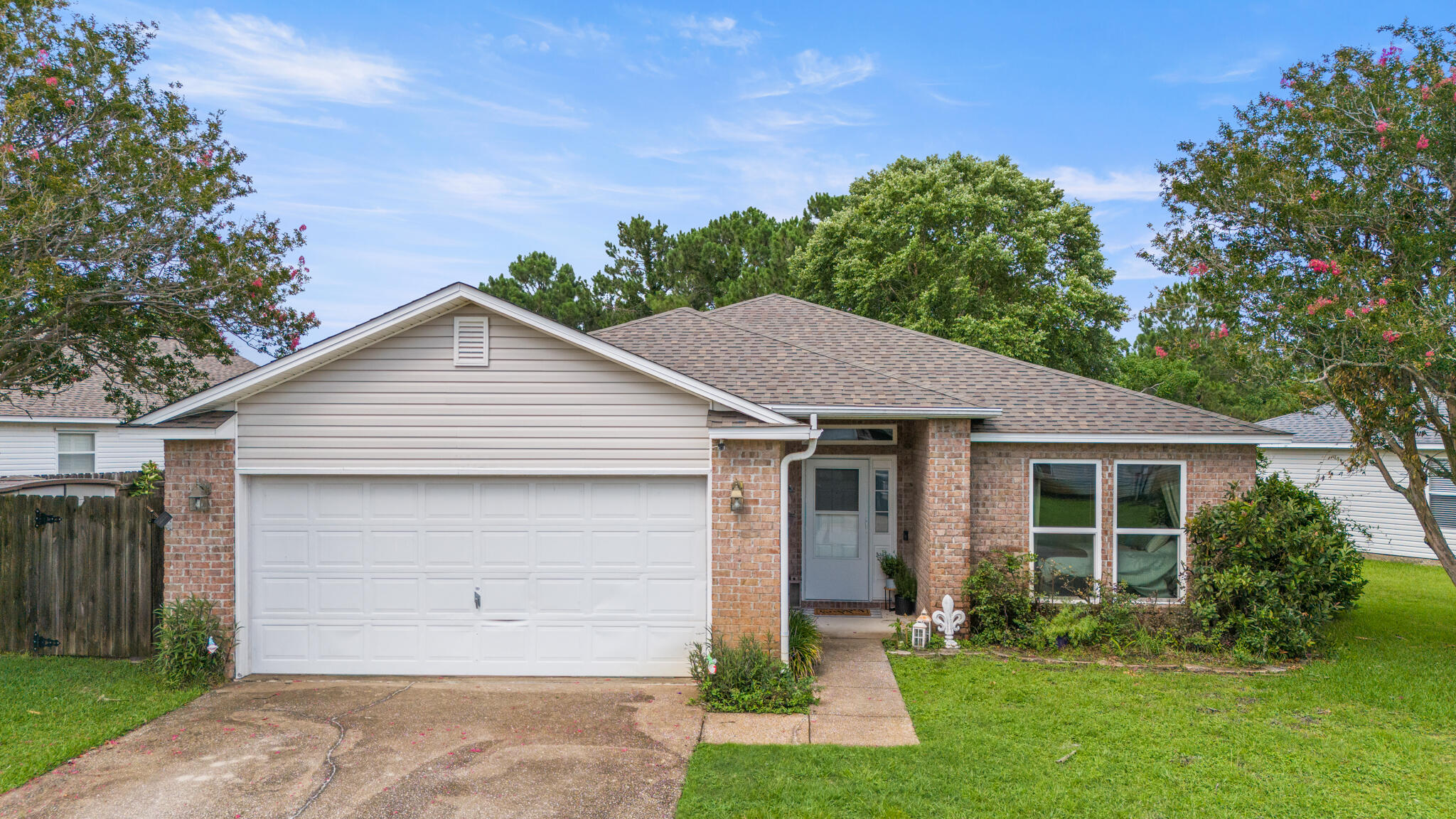 Tucked away in the quiet, family-friendly neighborhood of Hidden Shores, this beautifully maintained 3-bedroom, 2-bath home offers a rare blend of tranquility and convenience--plus a stunning lakefront setting that makes everyday living feel like a retreat. Step inside to an open and inviting floor plan where the living, dining, and kitchen areas flow seamlessly together. Oversized windows frame views of the lake and its peaceful fountain, filling the space with natural light. The kitchen is both stylish and functional, featuring granite countertops, a sleek glass tile backsplash, a new Frigidaire refrigerator, and a full suite of stainless steel KitchenAid appliances all less than five years old. A wraparound hop-up breakfast bar invites conversation, while a spacious pantry and indoor laundry room add to the home's everyday ease.
Enjoy peace of mind with major upgrades already taken care of, including a 2020 roof, impact-rated windows and doors installed in 2022, a whole-home drinking and water filtration system, and a brand-new hot water heater (2025). The primary suite is a true retreat with a large walk-in closet and a beautifully remodeled ensuite bath that includes solid-surface double vanities, a jetted garden tub, and a separate tiled shower (2023). Two additional bedrooms with laminate flooring and a guest bath with quartz countertop ensure comfort for everyone no carpet in sight.
Step outside to your private backyard oasis where mature trees offer shade and privacy from neighbors. An expansive patio overlooks tropical landscaping and a picturesque lake with a lighted fountain. Follow your own gated path for direct access to the lake perfect for peaceful walks or simply enjoying the view.
Enjoy the best of both worlds: serene surroundings with convenient access to it all. Commuting is a breeze to Hurlburt Field and to NAS Pensacola.