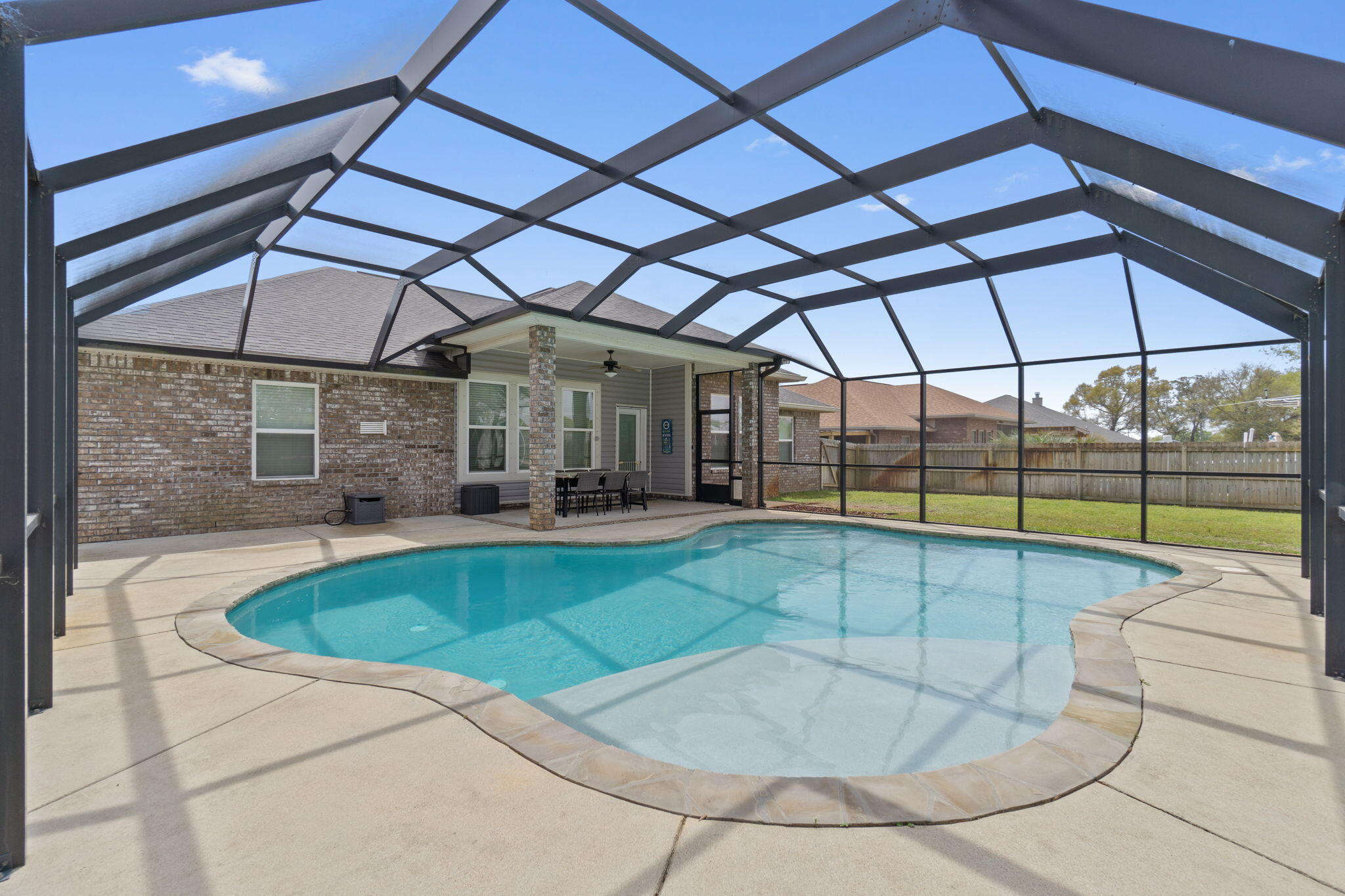 Welcome home to this stunning all brick home with a backyard oasis in the much loved and popular neighborhood of Holley Hills (no HOA)! Featuring 4 bedrooms, 2 bathrooms, a formal dining room, a custom gunite ozone inground pool (with a screen enclosure), fully paid off solar panels, AND a whole home water purification system - this better than new home surely has all features you've been waiting for! Bring your boat or RV because this home also has access from the back of the property through a double gate with additional concrete parking! Pull into the driveway and you'll appreciate the updated landscaping, and pass through the covered front porch to find soaring 10ft ceilings in this open concept plan along with great upgrades like bull nose corners in the living areas. To the left when you enter is the formal dining room, and the large living room is open to the well appointed kitchen where you'll find a functional and fantastic sized kitchen island, granite countertops, stainless appliances, drop down pendant lighting, additional recessed lighting, tasteful tiled backsplash, a great sized walk in pantry, and eat in kitchen area. This floor plan features a split layout providing master bedroom privacy, and the great sized owner's suite features a trey ceiling and a stunning en suite bathroom complete with a large walk in closet, double vanities, a private water closet, a separate soaking tub, and separate shower. The other three additional bedrooms are located on the other side of the house each with ample closet space (2 of which have walk in closets!). Outside is where you'll enjoy the best of Florida living with the fully screened in pool with a concrete deck where you'll love entertaining and making memories! The fully privacy fenced backyard also has a chicken coop and run which can convey - including the egg laying hens! Enjoy being minutes to Navarre's beautiful beaches, a short commute to Hurlburt Field, and direct access to hiking trails, the new Donna Nelson nature park, East Bay River, and Eglin hunting range. Have peace of mind with a termite bond through Premier Pest Control, purified water and enjoy all the cost savings with solar panels covering your power bill! Don't miss the full list of seller updates!