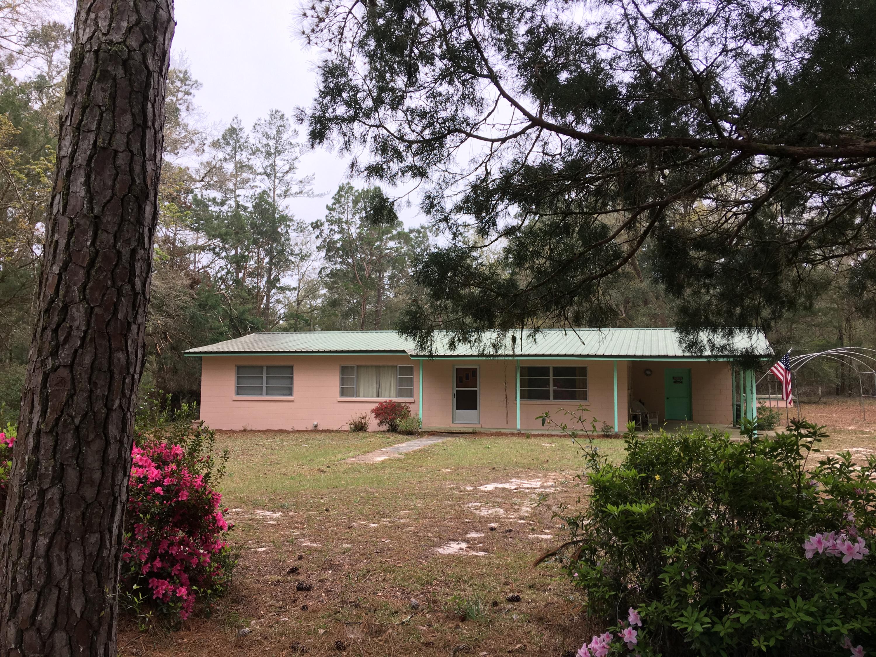 Looking for the quiet life? How about 10 acres in Red Bay, just 30 minutes from the beach?! This well-maintained home is solidly built with block construction and metal roof, and is surrounded by forest with old oaks, magnolias, and dogwood trees. The master has an adjoining room that could be used as an office, sitting room, or nursery. Plenty of room to spread out and add a garden, pool, horses, goats, and more. Deep well and septic. Gas furnace, oven, broiler, and cooktop. Refrigerator, dishwasher, washer & dryer, and chest freezer also convey. Most furniture is also available at an extra cost. This home has not been updated, but that is also part of its charm. Metal roof is 15 years old, furnace replaced 7/03, well pump replaced 5/11, water heater replaced 7/18.