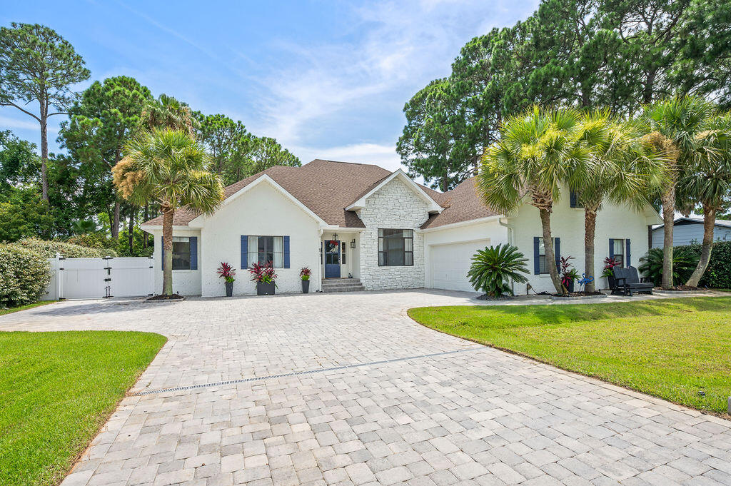 Florida living at it's finest! This beautiful 4bdrm 3 bath brick home has great curb appeal and the backyard of your dreams!!! All new in 2023-heated gunite pool, hot tub with fire pits, a covered outdoor kitchen with breakfast bar and an expansive patio to entertain all of your friends and family. Just a quick golf cart ride to Pompano Joe's and the beach too! There is even a double gate on the side of the house for you to park your boat or camper AND a heated/cooled garage! New hot water heater in 2025. New generator and main HVAC in 2023. New roof in 2022. Inside you will find a spacious living area, an updated kitchen, a formal dining room and office on the front of the home and an exquisite owner's suite complete with trey ceilings, a fireplace and a completely remodeled bath. There is a double vanity, soaker tub and a shower that is to die for. There are also two bedrooms and another full bath on the other side of the home. The 4th bedroom is located upstairs and is currently being used as a bonus/game room and it also has it's own bath as well. This home is impeccably cared for and is a must see in person! The extensive paver drive way and the expansive, private backyard oasis makes this home easy to maintain and an amazing place to entertain. This beautiful, quite waterfront community is a great place to call home. There are no HOA fees and while the homes in this area are primarily owner occupied, you can use this home as a short term rental if desired. You are 1.7 miles to the public beach at Pompano Joe's. There is also waterfront park just down the road and beautiful homes all around you. Schedule your showing today to see all this home has to offer!