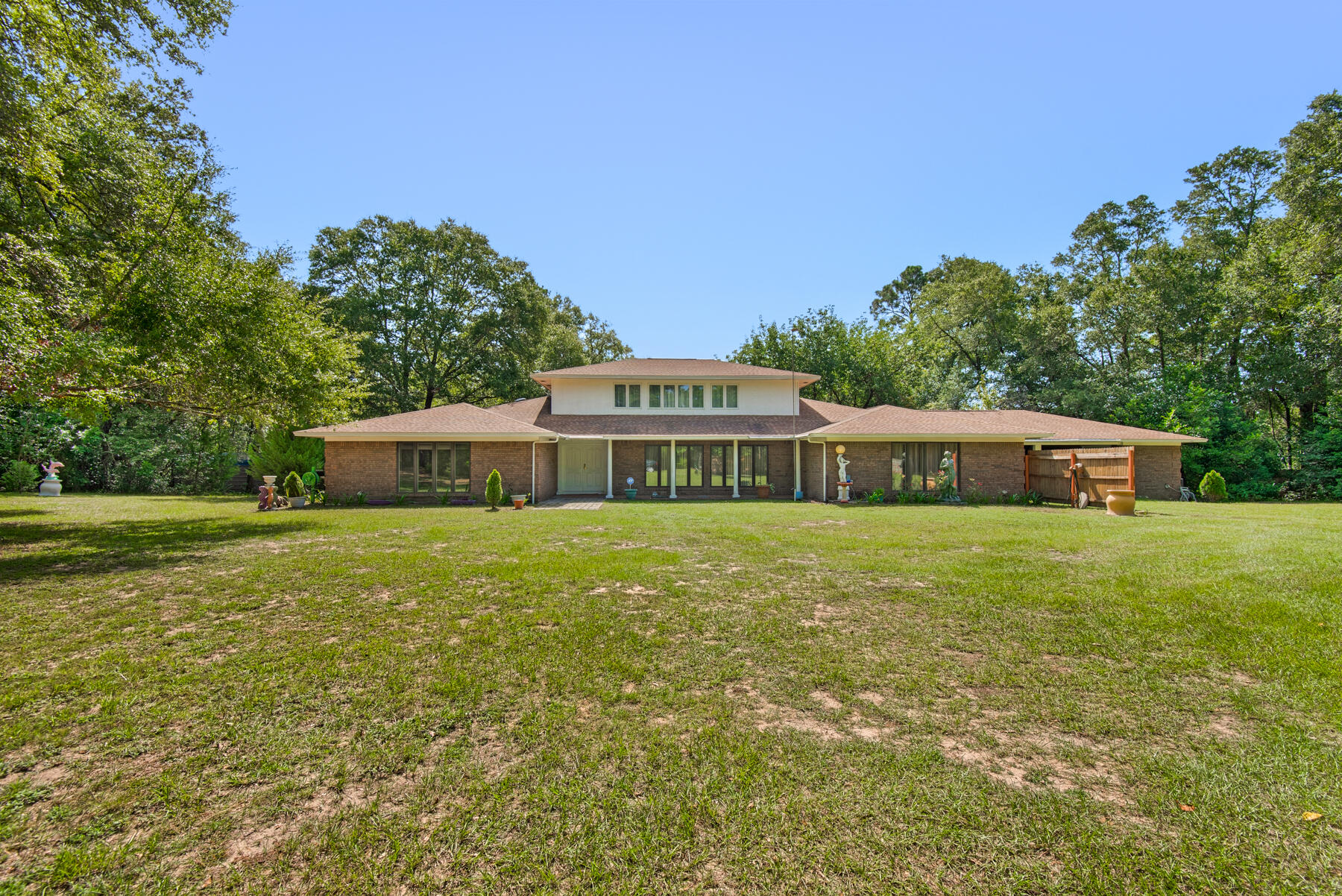 Nestled on a sprawling 2-acre landscape, this 6 bedroom home exudes a sense of nostalgia and tranquility all while boasting ample living space. The interior exudes a vintage charm. As you move through the home, you'll discover a blend of nostalgic details and the potential for modern updates. Venture upstairs to discover two bedrooms and a bathroom creating an exclusive space that offers a sense of privacy within the home. This layout is perfect for extended family stays, creating guest accommodations, or setting up a home office away from the main activity areas. On the main level, the oversized master suite is complete with an ensuite