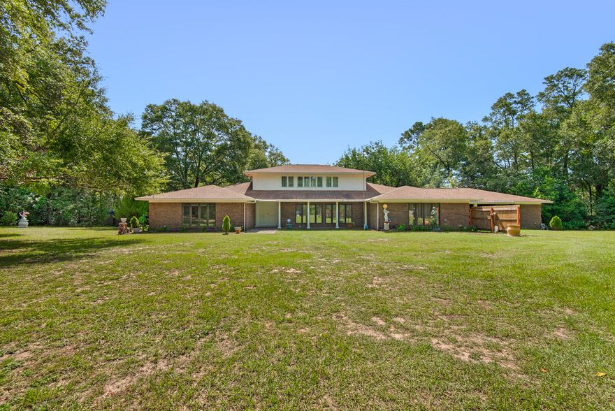 Nestled on a sprawling 2-acre landscape, this 6 bedroom home exudes a sense of nostalgia and tranquility all while boasting ample living space. The interior exudes a vintage charm. As you move through the home, you'll discover a blend of nostalgic details and the potential for modern updates. Venture upstairs to discover two bedrooms and a bathroom creating an exclusive space that offers a sense of privacy within the home. This layout is perfect for extended family stays, creating guest accommodations, or setting up a home office away from the main activity areas. On the main level, the oversized master suite is complete with an ensuite