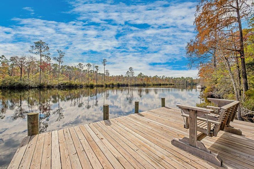 If first class carpentry, energy efficiency, deep water, nature, privacy and endless possibilities for the individual homeowner or investor appeal to you, do not miss out on this one!! Peace, tranquility and a private oasis awaits you, just minutes from the beaches of South Walton! This one-of-a-kind serene 2 bedroom, 2 bath exceptionally well-built home exudes craftsmanship inside and out with a separate studio guest house on property. The huge primary bedroom suite features vaulted ceilings, two tiers of windows with an abundance of natural lighting amidst tree top views, reading area, large tiled shower and whirlpool tub.