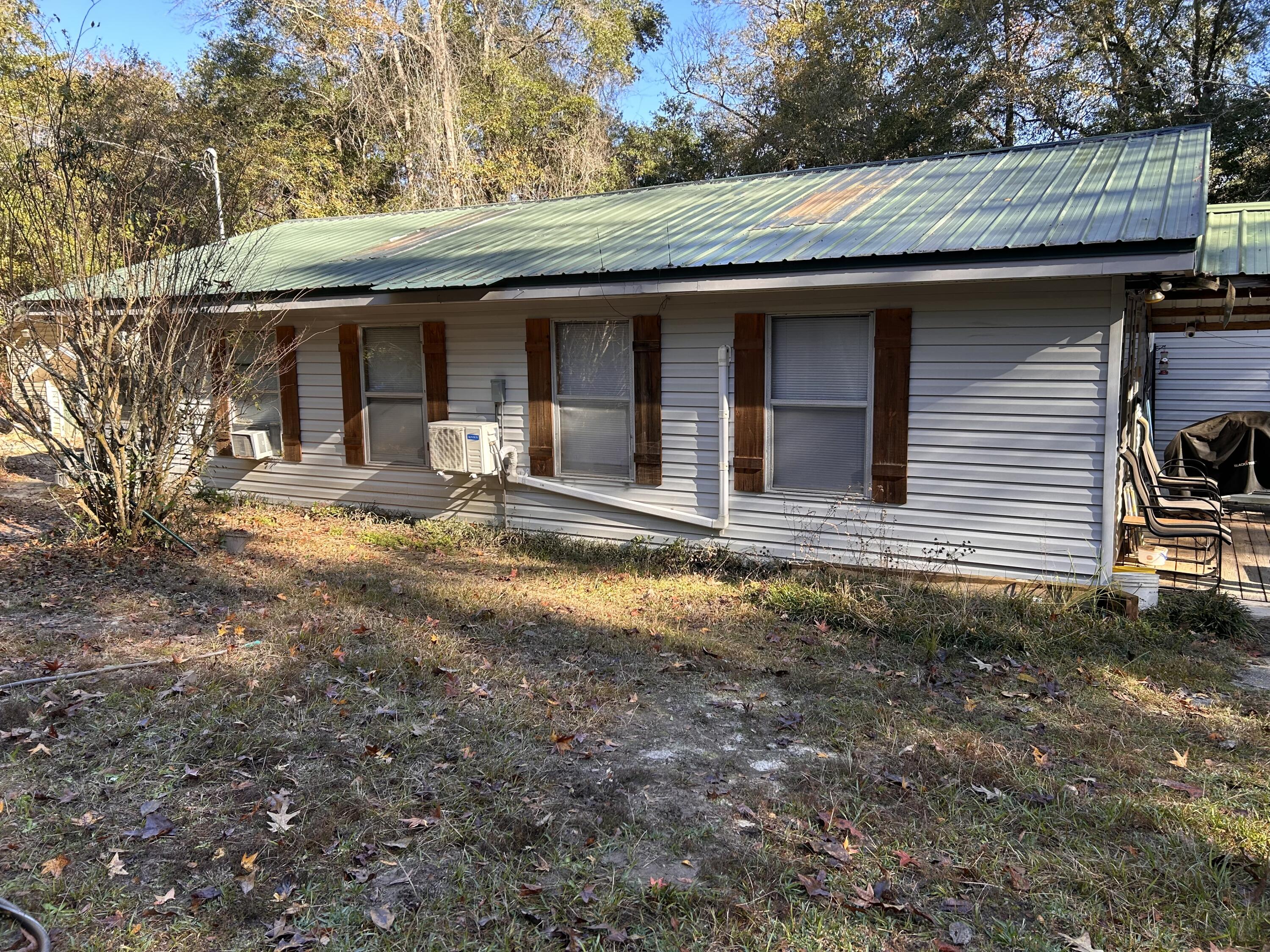 Rustic home on 5 acres in Baker great for a weekend retreat! The home is spacious and has plenty of room to spread out. The kitchen has solid wood cabinets and a walk-in pantry. The home is fully furnished and includes the washer and dryer and stainless steel fridge. There is a shallow well for drinking water and a new deep well that was recently drilled but not connected. You will have plenty of storage with 3 additional out buildings. The largest has electricity for the handyman. The land gently slops to a creek in the back of the property and has a deer stand in place.