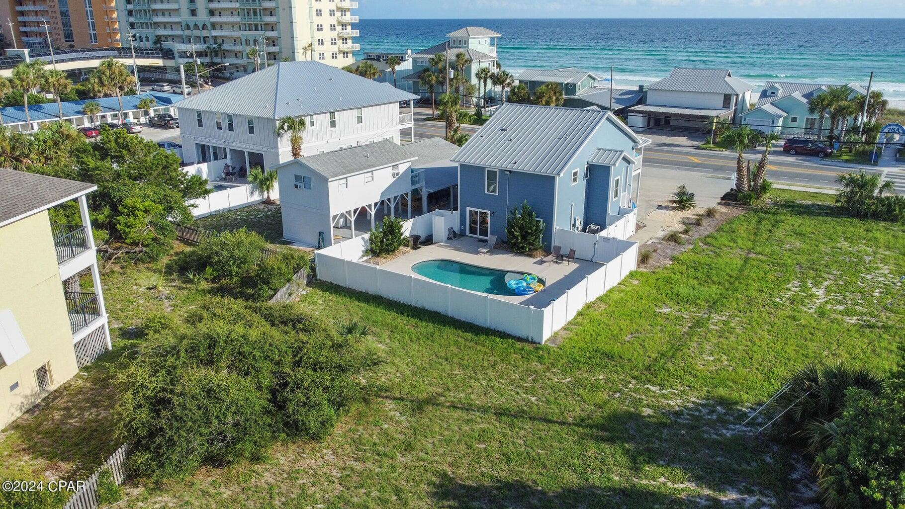 Welcome to your custom built, one owner, dream vacation home, 'Breezy Blue Cottage 'in Panama City Beach, Florida! This stunning property offers gulf views and is perfectly situated directly across the street from beach access #76A, ensuring easy and quick trips to the pristine shoreline. With 2700 square feet of luxurious living space, this home boasts 5 spacious bedrooms and 4.5 bathrooms, designed to comfortably accommodate up to 20 guests, 16 guests comfortably.. Unique features include exquisite porcelain tile plank flooring throughout the home; gorgeous kitchen featuring marble backsplash and high end Granite counters; a master bedroom en suite on both floors. A bunk room en suite with two sets of adult queen bunk beds, with each mattress supporting up to 300 Ibs (SEE ADD REMARKS) ...making it an ideal choice for large families or groups of friends. The home is built to last with an aluminum roof that comes with a 50-year warranty, Everlast composite siding and this home is equipped with two HVAC units for efficient climate control on both floors. This property is sold fully furnished, allowing you to move in or start renting it out immediately. Speaking of rentals, this house is a proven rental machine with excellent reviews, boasting a remarkable 9.6 out of 10 rating on VRBO. Outdoor living is equally impressive with a 30x14 gunite saltwater pool, surrounded by a large deck featuring Cool-Crete deck coating, perfect for lounging and entertaining. The home's prime location offers close proximity to shopping, restaurants, Pier Park, and the famous 30A corridor, providing endless opportunities for entertainment and exploration. Don't miss out on this rare opportunity to own a piece of paradise in
