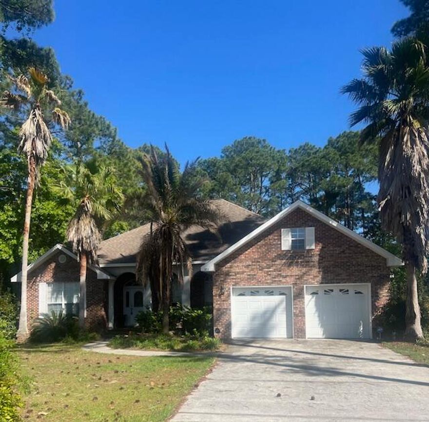 Huge price reduction on this Fixer-Upper with Unlimited Potential.   Discover this hidden gem nestled on a large, private lot, set back 277 feet from the road and backing up to serene woods. This 3-bedroom, 2.5-bath home offers a spacious, open floorplan with 12-foot ceilings adorned with crown molding. The home is thoughtfully designed for both relaxation and entertaining. The master suite opens directly to the screened-in pool with covered patio creating your personal oasis. The formal dining room with  electric- gas fireplace,  adds to its charm and character.  This property is not only directly across the street from the Bay but also conveniently located near the hospital, Grand Boulevard's shops and restaurants, and Sandestin Resort.   Plus, enjoy the freedom of no HOA fees