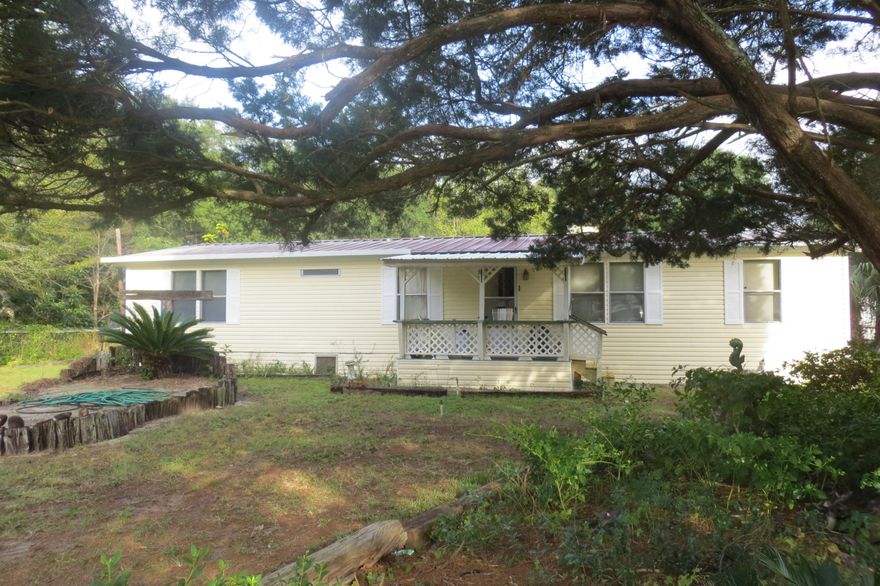 This half acre lot holds so much that will benefit someone that wants a work shop, green house, another building that needs a bit of tlc and manufactured home that needs a little bit of updating and a few small repairs. Being sold as-is but in good condition - everything works. Fireplace in a nice open floor plan that is in the living room. Dining room with built in cabinets and lots of storage that is great for keeping all those treasures. Built on room at the back for more storage and laundry area,. Yard is fully fenced with a chain link fence. Large beautiful tree sits on the front corner of the lot that gives it an amazing feel. The property offers so much - even park your big toys in the back for security. Come see for yourself the opportunities this home and lot have to offer.