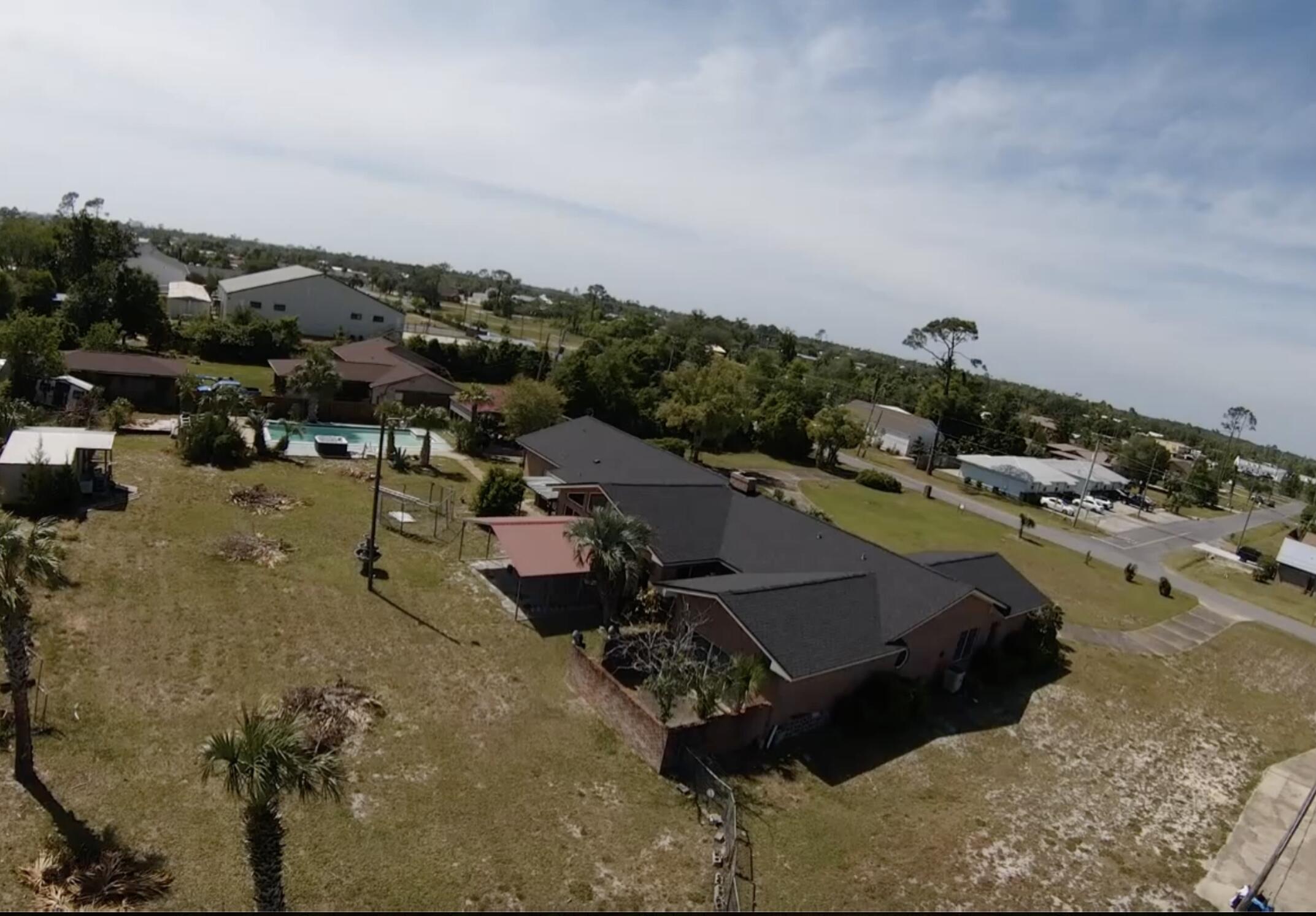 This unique home is located in the heart of Panama City on 1.5 acres! The lot features a extra large in ground guinte pool, hot tub, Large metal 3 bay garage, barn, shed, RV carport and 20x16 metal garage building.This large home features circular driveway and double door entry. w/ concrete block safe room. New roof in 2025. Interior features include crown molding, 30ft brick accent wall, floor to ceiling windows and beamed cathedral ceiling. The great floorplan easily accommodates a sizable family. Formal living room and dining room, wood burning fireplace, 2 cooktop stations in charming brick alcove in oversized kitchen with double ovens. Master bedroom has his/her cosets, jetted tub, private water closet, separate shower and double ink vanity. Each of the 4 bedrooms has its own bath. Large metal 3 bay garage, barn, shed, RV carport and 20x16 pool and hot tub. Equipped with 2 water heaters, 2 HVAC systems. All electric. The home in currently on 2 septic tanks, and well system but can connect to city water and sewer. Buyer should verify costs. Partially fenced back yard. Upgraded windows and security system. Please call before requesting a showing appointment. This home needs work, but you won't find anything else like this in this location. All buyers must have proof of funds and or loan approval for rehabilitation loan. Owner Financing may be available. Offer rate may change.
