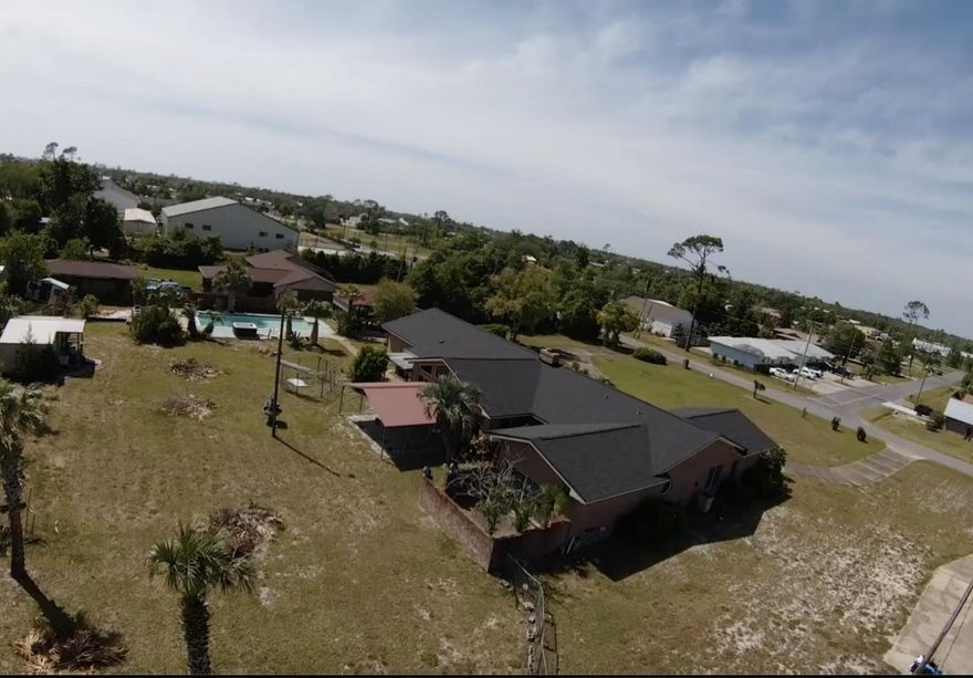 This unique home is located in the heart of Panama City on 1.5 acres! The lot features a extra large in ground guinte pool, hot tub, Large metal 3 bay garage, barn, shed, RV carport and 20x16 metal garage building.This large home features circular driveway and double door entry. w/ concrete block safe room. New roof in 2025. Interior features include crown molding, 30ft brick accent wall, floor to ceiling windows and beamed cathedral ceiling. The great floorplan easily accommodates a sizable family. Formal living room and dining room, wood burning fireplace, 2 cooktop stations in charming brick alcove in oversized kitchen with double ovens. Master bedroom has his/her cosets, jetted tub, private water closet, separate shower and double ink vanity. Each of the 4 bedrooms has its own bath. Large metal 3 bay garage, barn, shed, RV carport and 20x16 pool and hot tub. Equipped with 2 water heaters, 2 HVAC systems. All electric. The home in currently on 2 septic tanks, and well system but can connect to city water and sewer. Buyer should verify costs. Partially fenced back yard. Upgraded windows and security system. Please call before requesting a showing appointment. This home needs work, but you won't find anything else like this in this location. All buyers must have proof of funds and or loan approval for rehabilitation loan. Owner Financing may be available. Offer rate may change. 
