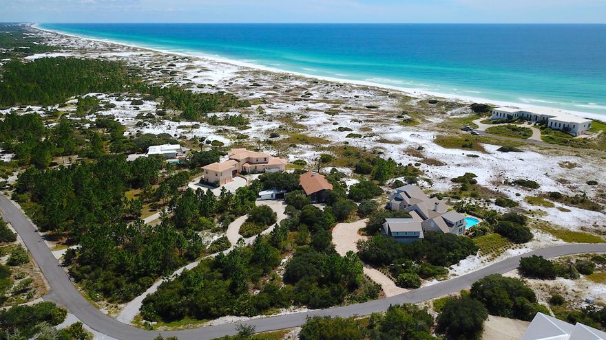 Four Mile Village is a place where nature can take precedence over the superficial and where those who appreciate nature in all her various moods and forms can find a haven. This private gated community expands across 300 acres of coastal paradise offering hiking trails, historical landmarks, a private coastal dune lake, and 2,200 feet of pristine white sand beach along the Gulf of Mexico. This approximately 1-acre lot is well-positioned to capture southern views and breezes from the Gulf, while enjoying the privacy and serenity of this low-density community. This mid-century home displays character throughout with a simplistic layout and design that remains timeless.
