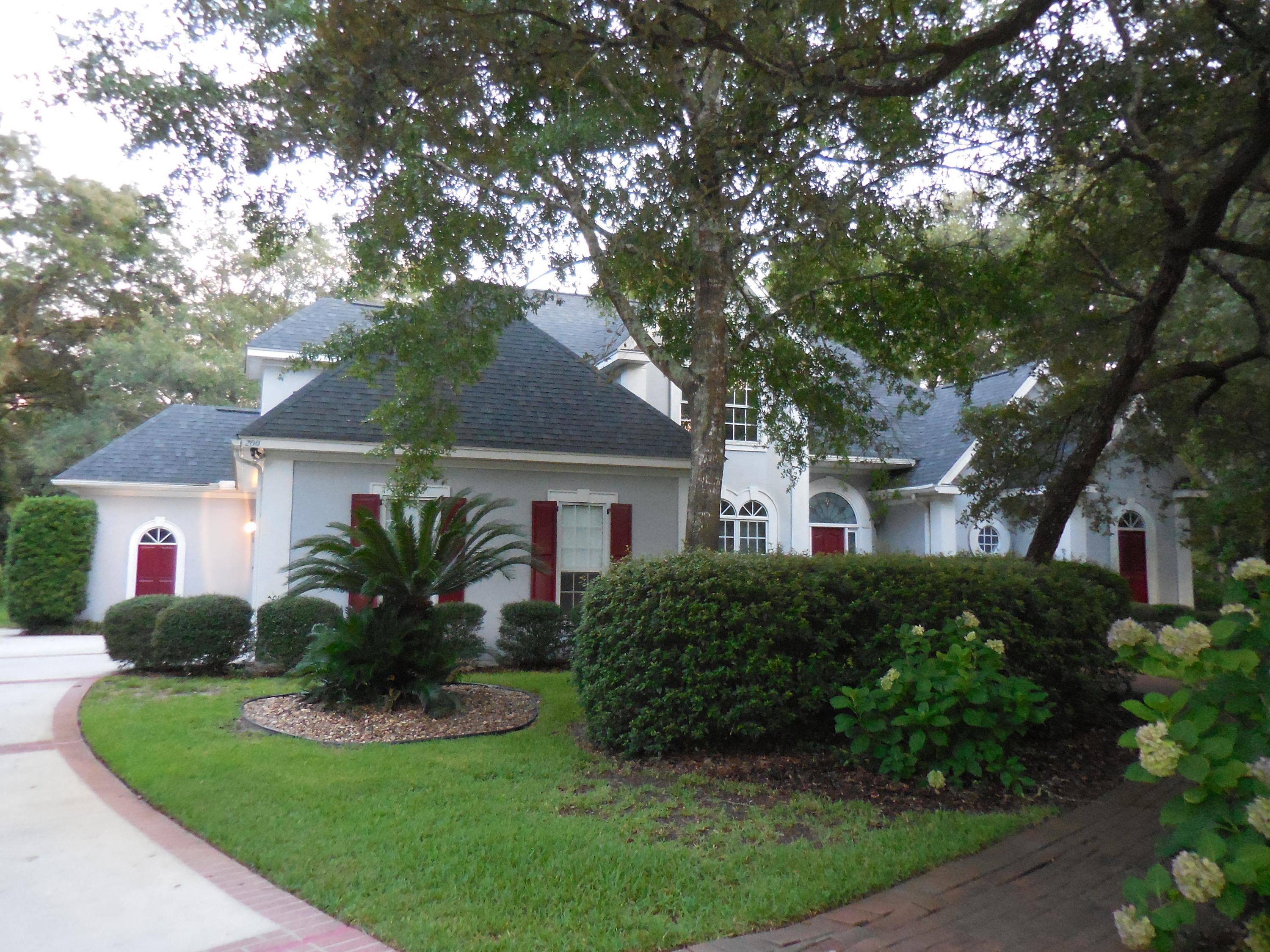 Graciousness Greats You with a 2-story foyer (marble tile) and open floor plan formal dining and living rooms (w/ shiny hardwood floors and columns)! The far wall of the living is wall-to-wall and ceiling-to-floor windows w/ patio doors leading to the beautiful brick pavered covered and open back patio. Next find a unique spacious kitchen w/ b-fast bar, which can seat 6, an informal dining area and a cozy sitting area. The 1st floor master suite is a delight with the huge bath (whirlpool tub and separate shower) and gigantic walk-in with 3 sections! Upstairs bedroom 2 has a private bath and walk-in. Bedroom 3 has a sitting room as well as a bedroom and shares a Jack-N-Jill bath with bedroom 4. A golf cart and 2-car garages, laundry room, walk-in pantry and 1/2 bath round out the features!