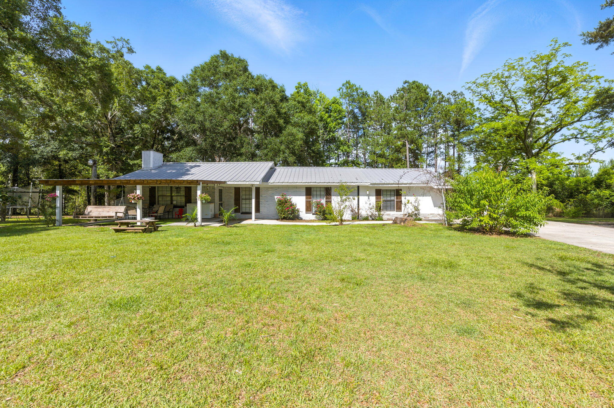 Welcome to your little slice of country paradise! Nestled on 2.46 acres, this updated 4-bedroom, 3-bath home is ready for chickens, goats, or just a peaceful life surrounded by nature.Step inside to find a cozy floor plan with warm wood-look tile flooring throughout and luxury vinyl plank in the spacious primary suite. The living room features a charming wood-burning fireplace with built-in bookshelves, perfect for relaxing evenings or showcasing your favorite reads.The kitchen features granite countertops, a newer stove/oven and refrigerator, and an island for extra counter space. Two of the four bedrooms are large enough to serve as primary suites, with the main suite measuring a generous 20x19 and featuring a walk-in closet. The fourth bedroom has a private bath ideal for multigenerational living, a game room, or guest space.
The fully fenced property includes several outbuildings, chicken coop, firepit, and plenty of room to run and roam.
Located just a short drive to Crestview, DeFuniak Springs, I-10, and even the beach you'll enjoy the serenity of the country without sacrificing convenience.
Bring the animals, bring the toys, bring your dreams, this is country living with convenience. Schedule your showing today!