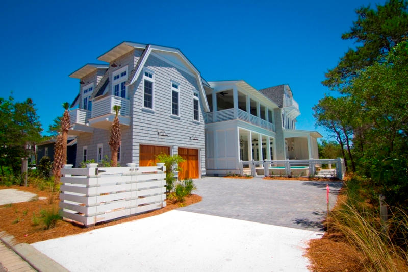 Exquisite design meets coastal elegance in this Gulf-view WaterSound home designed by Geoff Chick. This 4,503 square foot home exceeds all expectations. Outdoor living is the core of the home, with over 1,700 square feet of covered decks and porches. A full summer kitchen sits to the east of the tranquil infinity edge pool surrounded by ample covered deck space for poolside dining and lounging. The interior of the home leaves nothing to be desired, grey washed oak floors flow throughout all three stories, Bevelo lighting fixtures suspend from 12 foot ceilings, and breath taking Gulf-views can be enjoyed from the second and third floors. The first floor of the home is composed of a grand living space and kitchen that wraps around the pool deck. The kitchen is anything but ordinary