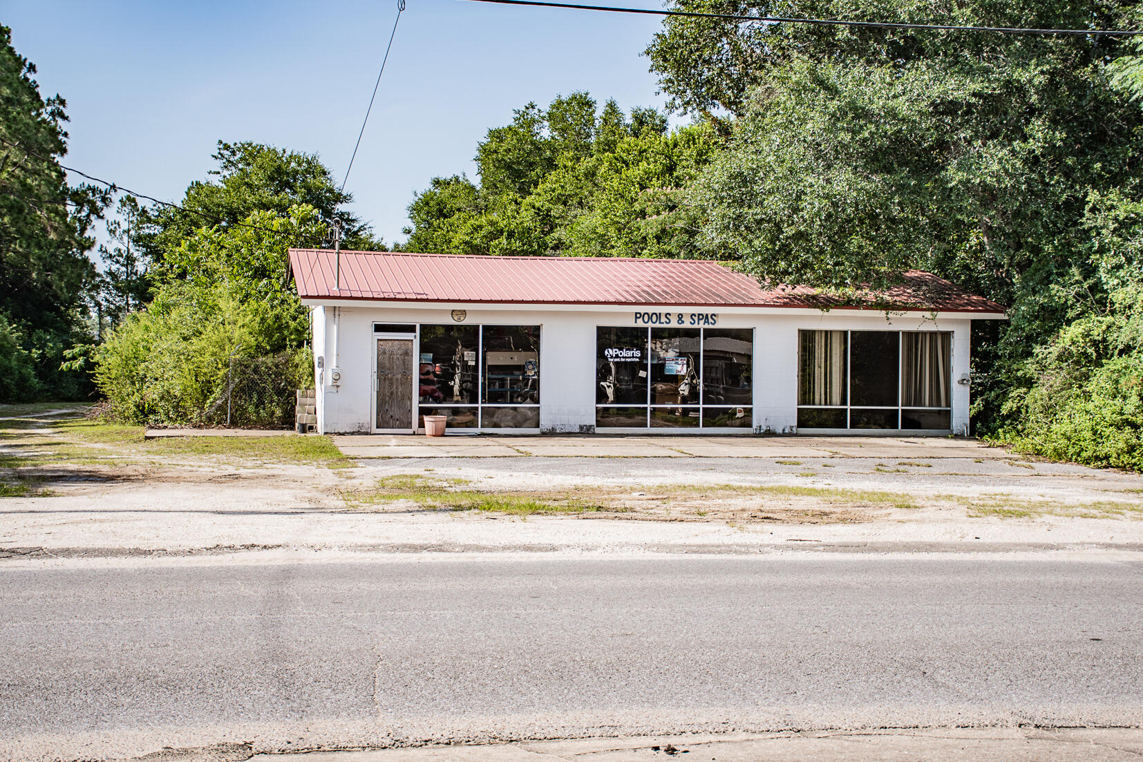 Investment/Business Opportunity! As you walk in, you will notice ample floor space for a shop or retail area, service counter, and a glass display closet. In the back, there are 4 office spaces and two bathrooms. The 1.5 acre lot provides plenty of space for a future parking lot, storage or working area. The property can be annexed into Crestview City limits as C-2: Commercial High-Intensity which includes potential for restaurants, large-scale retail sales and service industries, entertainment, light manufacture and repair, professional offices, hotels, gas stations, other similar uses and allowed accessory uses. Uses may be limited by location due to impacts and compatibility issues.