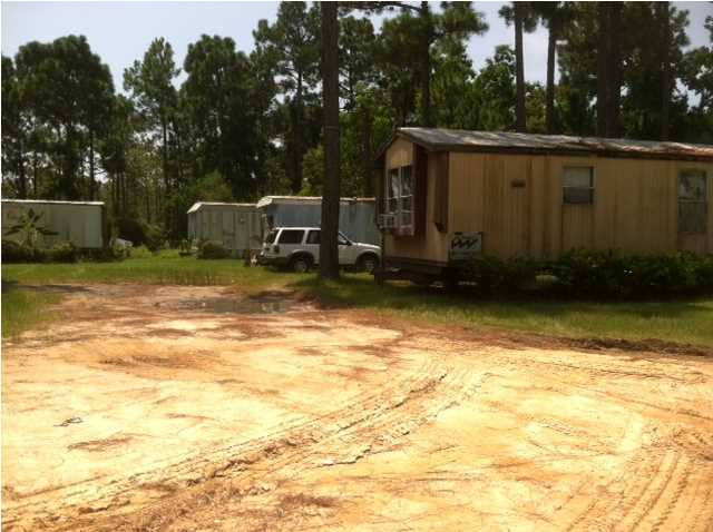6 Mobile homes on this site, only 2 are habitable. This property could probably be split into two separate lots. Checking on water and sewer. Currently there is a community water system in place owned by the seller. Room dimensions to be determined. Value is primarily in the land and rental income. The structure itself needs major repairs. This lot backs up to Point Washington State Forest.