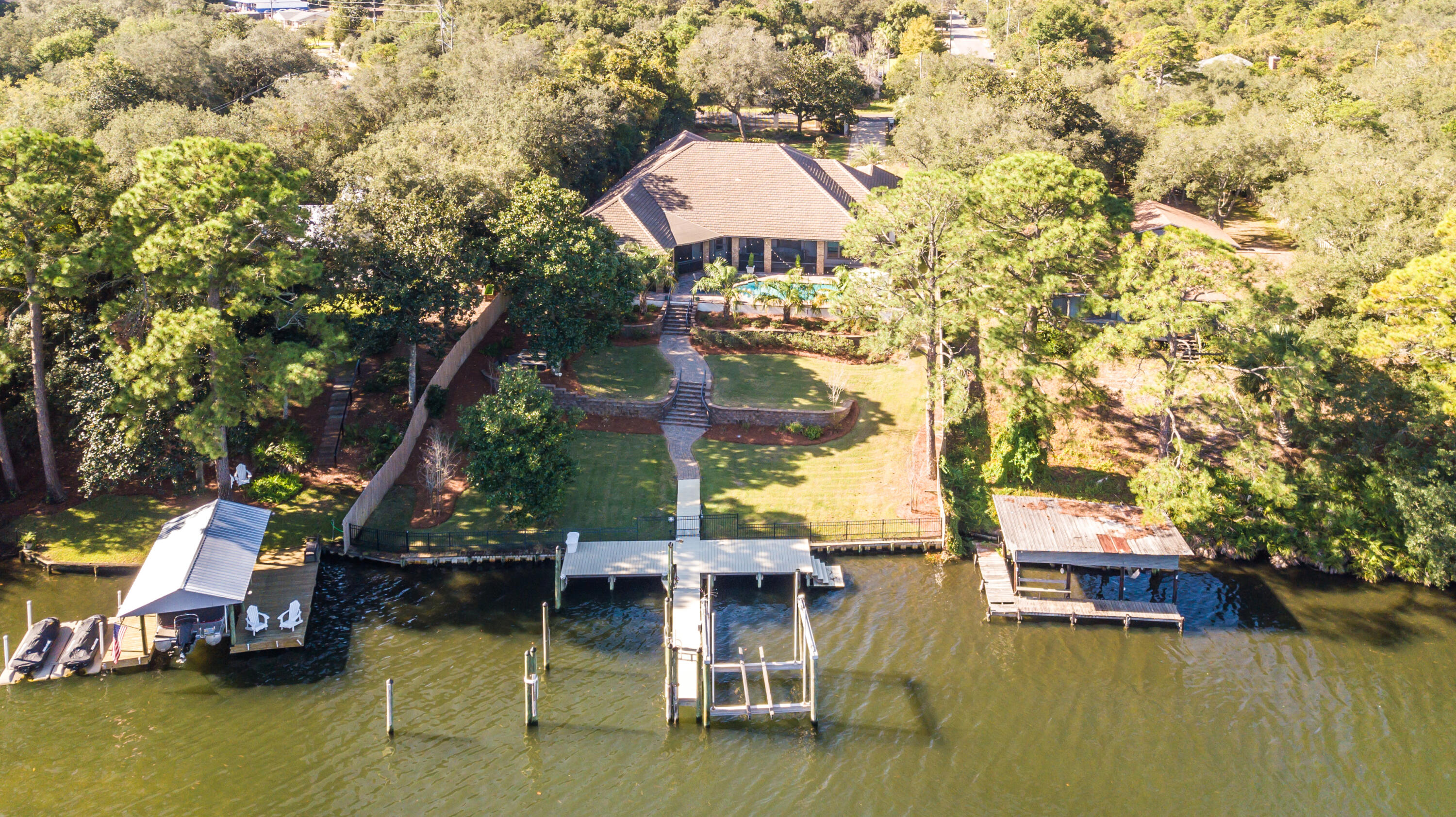 This Immaculately cared for, single-story, waterfront home on Joe's Bayou is a boat lover's dream. This 4 bedroom, 4.5 bath home on a three quarter of an acre lot has 100 feet of deep waterfront footage. The new composite dock has a 20,000 lb lift that has accommodated a 40 foot boat as well as a wet spot that can park a 45 foot boat. The home sits at over 20 feet of elevation and is in Flood zone X and was built in 2008. This part of Joe's Bayou is also a no wake zone and a dead end, making it a super quiet and a safe spot to park your boats. The screened in outdoor living and dining area is complete with a summer kitchen and bar, and plenty of room for entertaining. It is also perfect for enjoying the views and the yard and pool make for hours of enjoyment for family and pets.