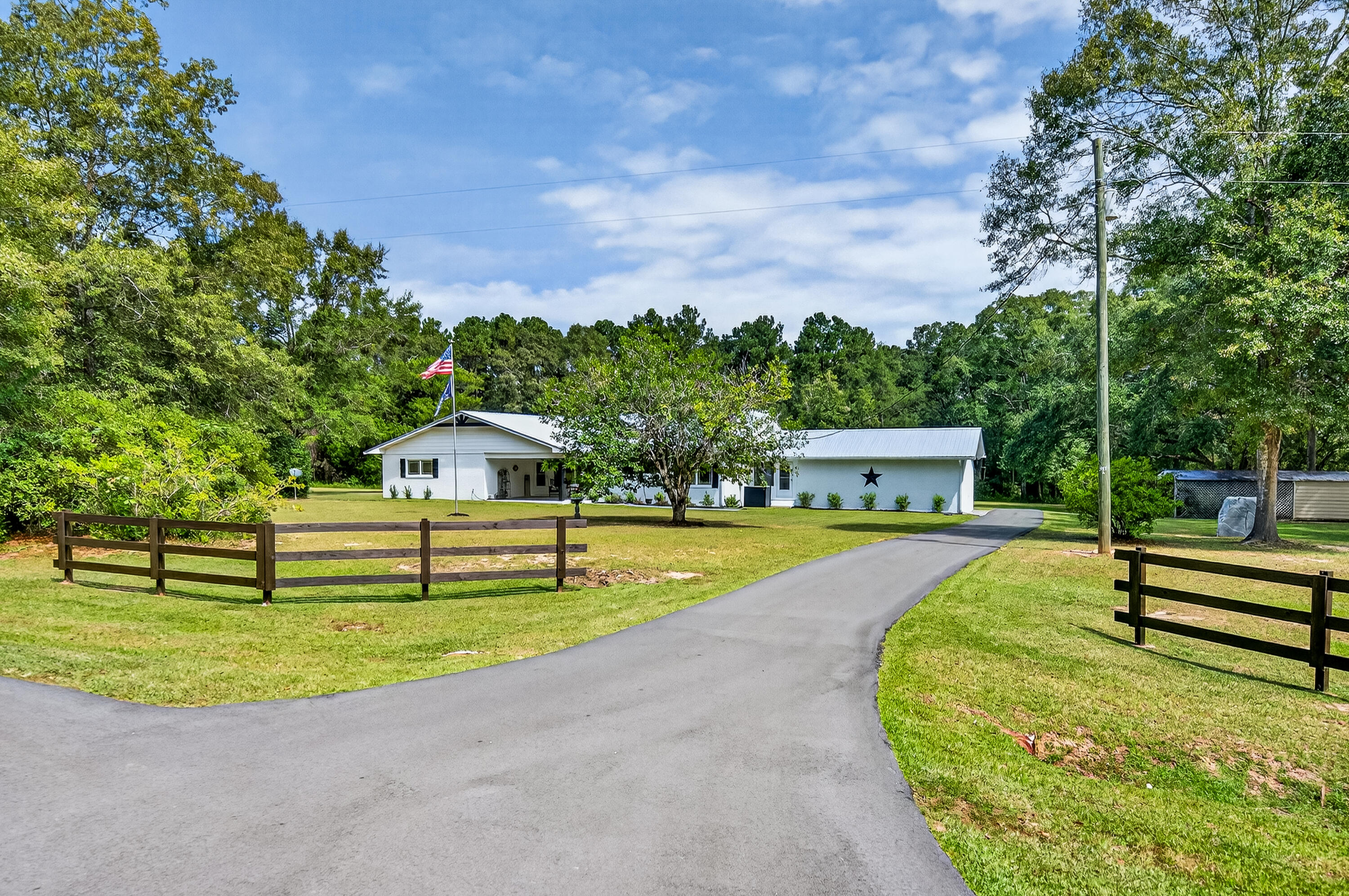 PRICED TO SELL at 25K BELOW appraised value!! Step into country charm with this beautifully renovated 3 bedroom/2.5 bath brick ranch on 15+ acres in Westville, FL! Nearly 3,000 sq. ft. of thoughtfully updated living spaces including a chef's dream gourmet kitchen with ample counter space, a walk-in pantry, breakfast nook and formal dining room. The expansive living room is a true centerpiece, offering both comfort and versatility. A stunning pine tongue-and-groove ceiling adds warmth and character, while rustic barn doors give the option to transform the room into an additional space--perfect for entertaining, a media room, or a cozy home office. The owner's suite offers a walk-in closet and a beautifully tiled shower, creating a comfortable haven. The expansive laundry/utility room provides exceptional space for storage and everyday convenience, while a glassed-in breezeway connects the home and garage, adding function and charm. Thoughtful updates include new flooring, fixtures, and energy-efficient Anderson windows, along with the durability of a metal roof and the security of a whole-house generator. Outdoors, you'll find a metal outbuilding, a 2-car garage, and a 2-car awning, offering abundant storage and workspace. With over 15 acres of cleared and wooded land, including trails for walking, horseback riding, or ATVs, this property is ideal for a hobby farm, gardening, or simply enjoying wide-open country views from the covered porches. Set back on a paved road close to town, that offers both privacy and convenience in a move-in-ready home. Endless possibilities await!