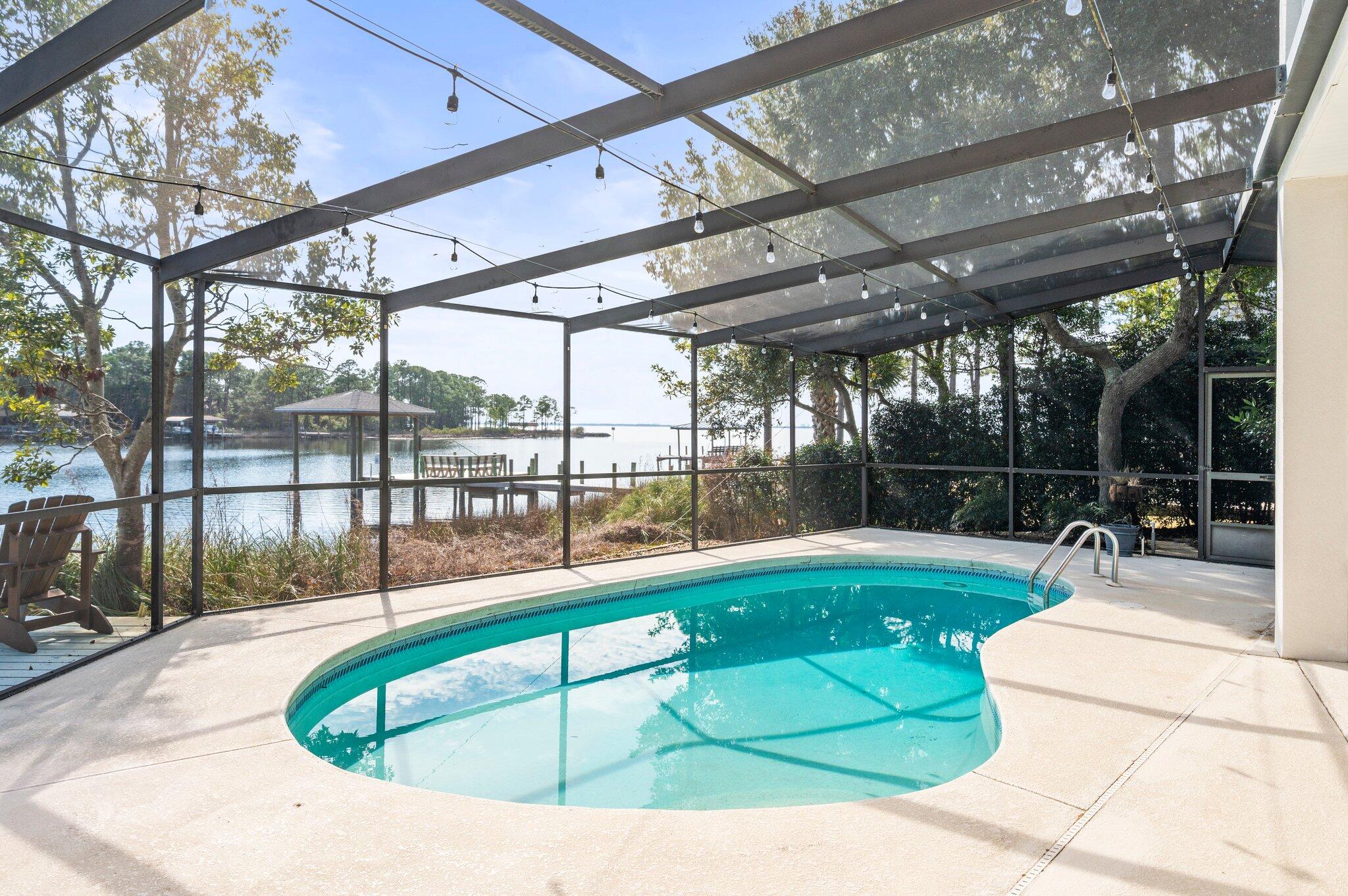 **For 2/7 and 2/8 OPEN HOUSE Events, CALL Bryan 850-797-2436 for community gate access when guard is off duty** Claim your piece of paradise with this spectacular WATERFRONT HOME cloistered within the gates of Bluewater Bay's Southwind community. 4400 Windlake Drive is an extraordinary property, positioned perfectly to enjoy both SUNRISE and SUNSET along PROTECTED Grass Lake with immediate access to Choctawhatchee Bay. From the wide and welcoming foyer with soaring ceilings and dramatic staircase to the open concept kitchen, dining, and living space beyond, the water remains on center stage. Find expansive water views from nearly every room in the home including all four bedrooms! Refresh in the POOL, dine alfresco, or host the masses inside the generously sized screen enclosed pool deck also overlooking Grass Lake. Relax and unwind around the fire pit just outside the screen enclosure or wander to the thoughtfully redesigned dock and boat house (2019) for a breathtaking, immersive wildlife experience as dolphins, manatees, schools of fish, waterfowl, osprey, bald eagles, and even a family of otters play! Indoors, this home exceeds expectations in terms of functionality, flexibility, comfort, and style. Boasting over 3,500 square feet of living space, an oversized 2-car garage with a tandem golf cart extension, and multiple walk-in attic storage areas, discover a place for everything and everything in its place.  In addition to the living, dining, and kitchen area at the heart of the home, the main floor also features a formal dining room currently used as an office, a cozy family room with gas fireplace, a laundry/utility room with work sink and ample storage, a stylish half bathroom, a super functional flex room currently used as a home gym, and a serene primary bedroom suite with access to the pool enclosure. The second floor offers three spacious bedrooms, one full bathroom, a bonus room with direct access to one of two attic storage spaces, and a covered balcony overlooking the water and accessible from two bedrooms. 
Showings begin with OPEN HOUSES Friday February 7 4-6pm and Saturday February 8 10am-1pm. 
4400 Windlake Drive represents a special opportunity to own a waterfront pool home in gated Southwind, one of Bluewater Bay's most desirable communities. Take full advantage of all that Bluewater Bay resort has to offer including golf, tennis, pickleball, pools (separate fees/memberships available for all these amenities), miles of recreational trails, a marina complex and boat ramp, restaurants, shopping, health care, and more are all within easy reach. Zoned for Bluewater Elementary School, with a choice of Destin or Ruckel Middle School, and Niceville High School. Whether by boat or car, arrive quickly and easily across Choctawhatchee Bay and enjoy the Emerald Coast's world-famous white sand beaches, entertainment, shopping, and more in Destin and 30A.
