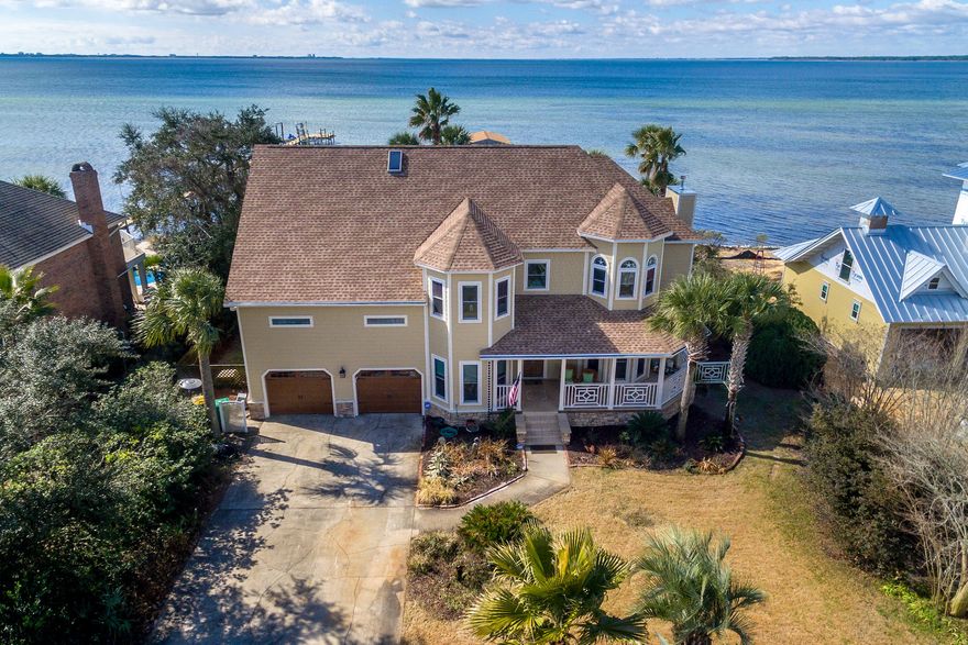 Remarkable estate located on a private, dead end street with panoramic views of the bay and year round sunsets! This home offers the ideal backyard oasis with a black gunite in-ground pool, summer kitchen, covered terrace, beach lounge area, and private boat dock with a covered boat house & single jet ski lift. In addition to the bay view, this home is located across the street from the 9th tee-off of Bluewater Bay Golf Course. Indulge in updates galore! ALL NEW: Full 3rd guest bath ensuite 2018, Exterior Hardy Plank siding, Luxury vinyl plank flooring throughout, new roof 2017, remodeled master bath, fresh paint inside and out, new garage doors, master balcony 2017, windows & sliding doors 2012, 2 dual HVACs 2014, gas Rinnai water heater 2017, kitchen appliances 2014, light fixtures,