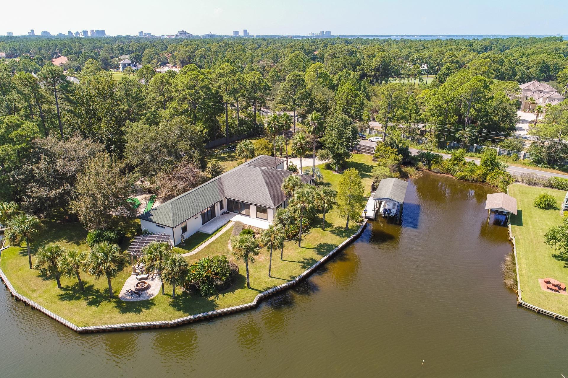 A truly unique waterfront oasis, conveniently located just behind Sandestin Resort & all of Grand Blvd shopping & restaurants. It is 2 separate lots totaling 1.17 acres, all on 513 ft of year round deep water on Buck Bayou. Build a 2nd home on the extra lot for family or to rent, sell it separately, or keep the whole thing as one private luxurious gated estate. This beautifully remodeled 3240sf 1 level home has 2 huge master suites, 2 additional bedrooms, 3 living areas, a flex room, gorgeous custom kitchen looking out over the bayou, lovely outdoor kitchen area, boat dock/lift, expansive lawns & full putt-putt course. This close-in quiet sanctuary feels incredibly private behind it's gated entrance & 10ft privacy fence. Gorgeous custom finishes, including reclaimed barn wood throughout!!