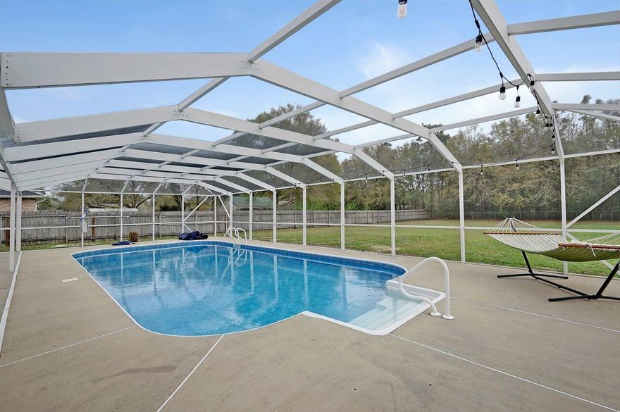 2.5% Assumable Rate to qualified VA Buyer. This is the unicorn everyone is chasing! 4 bedroom 2 bath POOL home on .60 acres! Meticulously cared for home boasts pride of ownership from the moment you pull in the driveway. Beautiful landscaping and covered front porch will greet you on your way in to this inviting home. Rich deep multi-toned wood floors accented by calming neutral paint colors throughout. The shiplap on the corner gas fireplace, open floor plan, and the raised ceiling in the living room provides a modern updated farmhouse feel. In the kitchen you will find ample cabinets and counter space that will impress the most discerning chef along with a giant island to gather around for meals or entertaining. The elegant granite is adorned by bright white cabinetry and newer stainless steel appliances. This former Parade of Homes winner doesn't stop wowing you there. Formal dining room with plantation shutters is large enough to entertain a large dinner party. All the bedrooms are very large with one bedroom offering ultimate privacy for guests suite. The master retreat is a calming shade of grey with plantation shutters and ensuite bath featuring granite counters, large soaking tub, and a separate shower. But the outside of this home is where you will truly fall in love. The 1800 square feet enclosed lanai features an 18x36 inground saltwater pool. Enjoy grilling under the covered porch while guests gather around the pool all while in the security of the screened enclosure. All this and there is still a yard big enough (over a half acre) for any kind of activity your heart desires. Technical aspects of this home include a new 50-yr dimensional shingle roof put on in 2016. Water softener installed in 2021. Pool liner replaced in 2020. Renovated kitchen, baths, fireplace and lighting in 2020. New carpet in master and 4th bedroom Aug 2025. This home has it all!