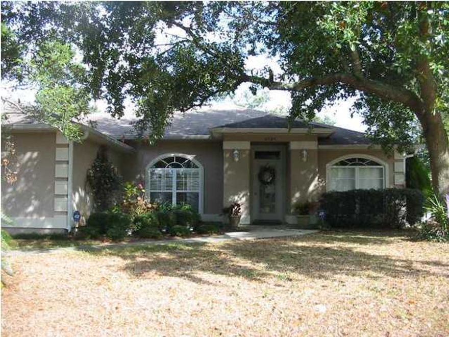 This perfectly maintained, stunning home is ready for you to move in and enjoy. The beautiful stucco home is nestled perfectly among majestic oak trees to create a Florida paradise. The screened patio is the perfect place to enjoy the privacy that the wonderful backyard provides and the common area behind home ensures no neighbors directly behind home. Inside the home, you'll truly fall in love. The open floor plan features wood laminate flooring that looks like wood but wears better. The formal dining room, living room and kitchen flow together to form a spacious, yet inviting, living area. The bright, open kitchen has plenty of cabinets and counter space. The master suite, tucked away from the rest of the home, features treyed ceilings, double vanities, and his/her closets closets and a garden tub. You really must see this home if you are looking anywhere in the Navarre area.