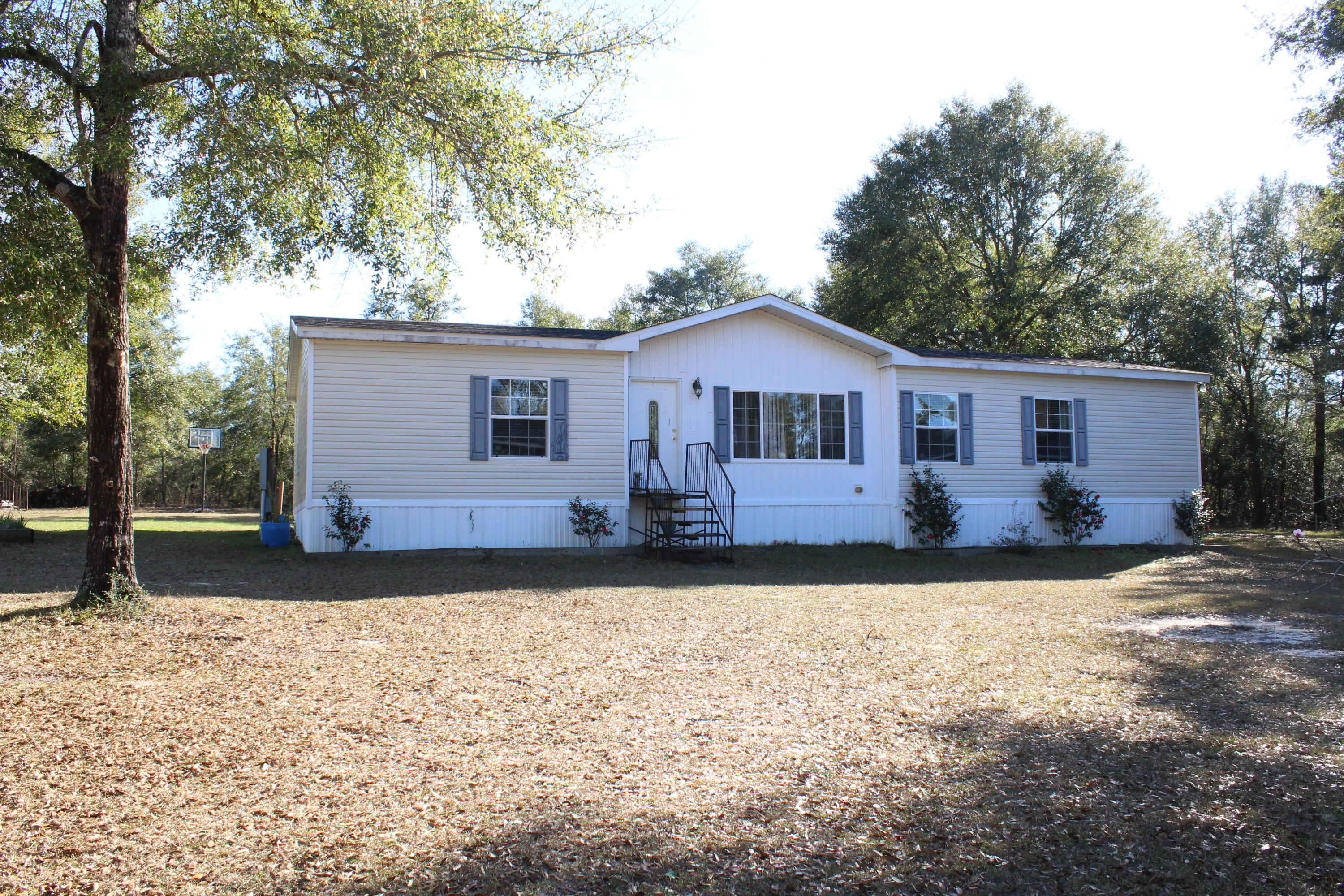 You don't see a deal like this often! 3/2 with over 1800 sq ft on 1.1 acres on paved road outside city limits but conveniently located to town! This home would be a dream for financing with the brand-new roof (April 2018) & great condition. Easy flowing open floor plan features a front living room & back family den with wood burning fireplace attached to the dining area & kitchen. The kitchen has a breakfast bar along with tons of cabinets & counter top space! One side of the home has the master bedroom suite while the other side of the home has two more bedrooms, a bathroom & bonus office nook! Outside is a newer workshop set up as an office with electricity, a large shed with electricity, raised garden, fruit trees & a back deck that would make cooking out a breeze! Don't miss out!