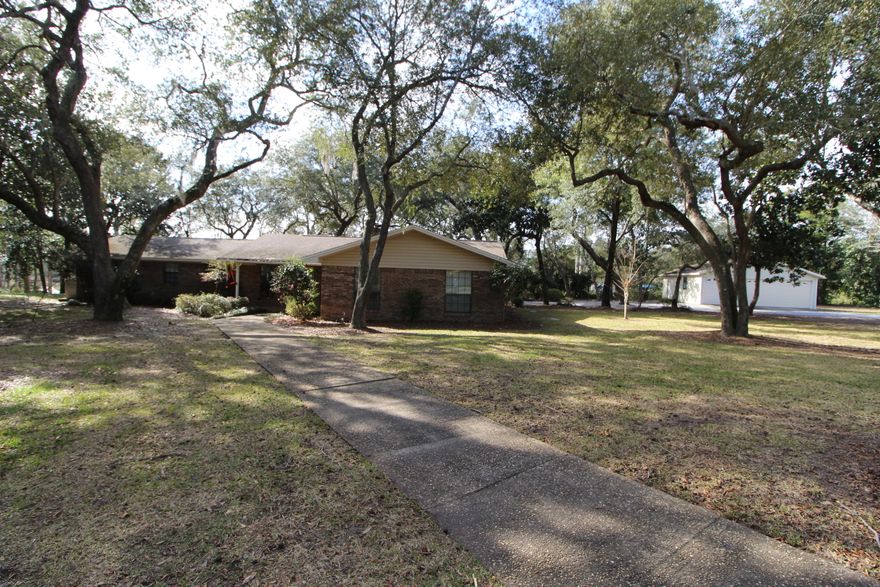 CRAB AND FISH FROM YOUR OWN DOCK! Pride of ownership shows throughout this well-maintained home situated in the desirable Robledal Estates neighborhood. Step into the tiled foyer to find a spacious living area with fireplace with custom mantle and hearth and boxed beamed ceiling. Enjoy sitting and relaxing in your all weather Florida room with windows that span across the backyard and water and allows access to the patio area. Light and bright kitchen with lots of cabinets, under cabinet accent lighting, corrian counter tops, tiled back splash, recessed lighting, pantry and a large counter height breakfast bar. Half bath conveniently located off the kitchen and dining area. Large room that could easily be used as an office/den or 5th bedroom with French doors that lead out to the deck area.  Dining area opens into the living area making entertaining a breeze.  Master bedroom has two closets one that is a walk-in closet.  Master bath has a walk-in shower and built-in cabinets for linens.  Three additional bedrooms and a full bath complete this perfect home.  Oversized detached garage with extra parking for your boat or golf cart.  Over an acre of nicely landscaped yard offers you a circular driveway, lawn pump and sprinkler system.  This home has never flooded and the insurance is very low!  Call today to take a look inside!