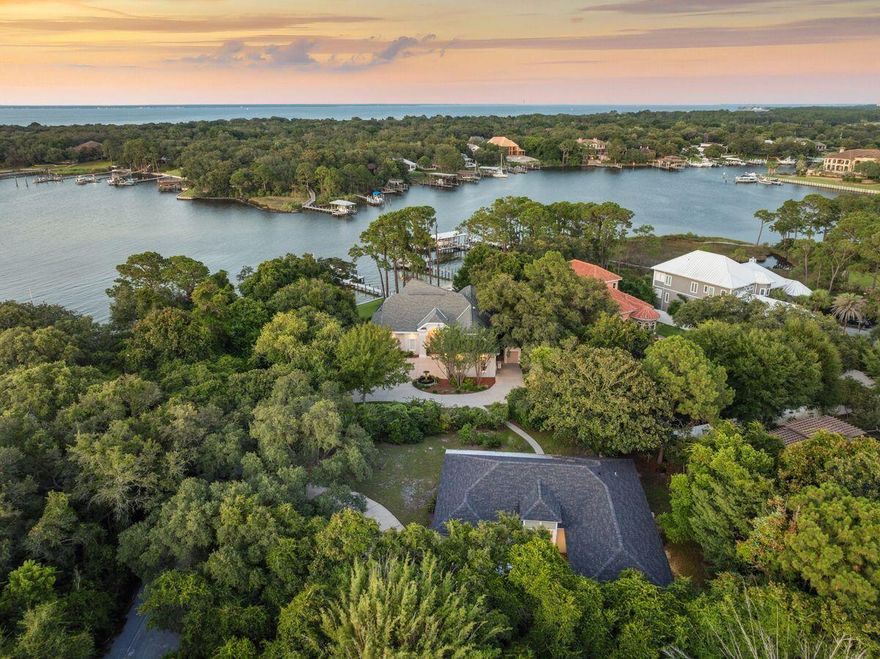 This property is being sold with 700 Beach Dr. See MLS 984070. Set along 103 feet of private waterfront on the storied shores of Joe's Bayou--one of Destin's most iconic and desirable addresses--this exceptional compound offers a rare opportunity to own a purposefully assembled, generational estate comprised of two distinct single-family residences across 1.35 acres. With direct access to the Gulf of Mexico just minutes away through the East Pass, and a backdrop of white sand beach, lush green space, and deepwater dockage, this estate was designed for a life well lived, and well shared. Recently reimagined by esteemed builder Frank Janssen, the primary waterfront residence at 702 Beach Drive is a masterclass in craftsmanship and livability. Constructed with aerated autoclaved concrete and positioned slab-on-grade, the home offers enduring strength while showcasing refined interiors and bespoke detailing. Twelve-foot ceilings, travertine floors, and a barrel-vaulted plaster entry ceiling set a sophisticated tone, while a custom kitchen impresses with Wood-Mode cabinetry, honed marble counters, a wenge butcher block island, Wolf and Sub-Zero appliances, and curated organizational features built for true chefs. The living room's wet bar, fireplace, and floor-to-ceiling windows connect effortlessly to a screened pool terrace, where views of the bayou unfold across the 90-foot private dock, sandy beach, and covered 30 plus foot boat slip. An outdoor shower at the dock makes rinsing off after a day on the water as effortless as the lifestyle itself. The main-level primary suite offers a sanctuary of comfort, with custom built-ins, a hidden vanity, concealed safe, and a spa-like bath wrapped in high-end quartz. A second ensuite bedroom upstairs accompanies a game and media lounge, opening to a large balcony with sweeping water views. Additional features include two additional bedrooms on the main level, a whole-house generator, tankless gas water heater, air purification system, and 2.5-car garage with workspace. Just across the landscaped lawn, the second residence at 700 Beach Drive offers completely remodeled flexibility for extended family, adult children, or long-term guests, with three bedrooms and two full baths, its own driveway and a private setting. Beautifully maintained and well-appointed, it complements the waterfront home while offering its own distinct sense of space and comfortperfectly suited for multigenerational living. Together, the two homes form a rare and remarkable compound where heritage meets modern luxury, and where every sunset over Joe's Bayou feels like it was made just for you.