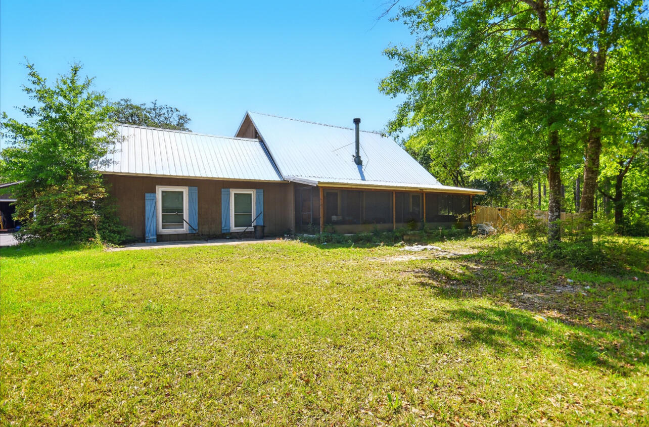 Looking for a cabin in the woods? This stunning private retreat on 5 acres, minutes from Interstate 10, boasts vaulted ceilings, a flagstone fireplace, a first-level Master Bedroom with a Loft Master, and inviting screened and covered porches, complemented by an inground pool, privacy fencing, and an oversized detached 2-car garage--perfect for your dream home or weekend getaway! Come see this home for yourself there is so much oppurtunity with % acres in mind.
