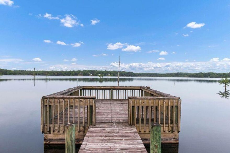 GREAT PRICE! BEAUTIFUL VIEWS! Treat yourself to the Spectacular views that come with this LAKEFRONT home! Florida Lifestyle 4 be/3 baths home, in the captivating views of Lake Holley, in DeFuniak Springs, FL. This hidden retreat exudes serenity from the moment you approach the property. Relaxing lakefront panoramic from the primary bedroom, kitchen, family room, 2nd floor bedroom, and even wider views from the covered back porch! ...Part of this property is a Manufactured Home, which has been attached and deeded to the 2 story Single Family residence that's on slab, due to Walton County Property Appraiser review in 2003, when the Agency determined that the mobile home complied with the code requirements for a permanently affixed structure.  The semi-open concept  provides a level of privacy, while still interacting with most social areas. The layout provides a second living/flex room convenient for multiple uses, such as a home-office, game room, a conversational area when entertaining, etc.....
A completely separate suite in the 2nd floor bedroom loft with full bathroom! The bathrooms, and the kitchen have been updated. Metal workshop/shed with power. Insulated and power-ready wood shed. New backyard steps. Pooled pump about 2 years old.  Part of this property is a Manufactured Home, which has been attached and deeded to the 2 story Single Family residence, on slab, after Walton County Property Appraiser reviewed it and determined that the property complied with the code requirements for a permanently affixed structure