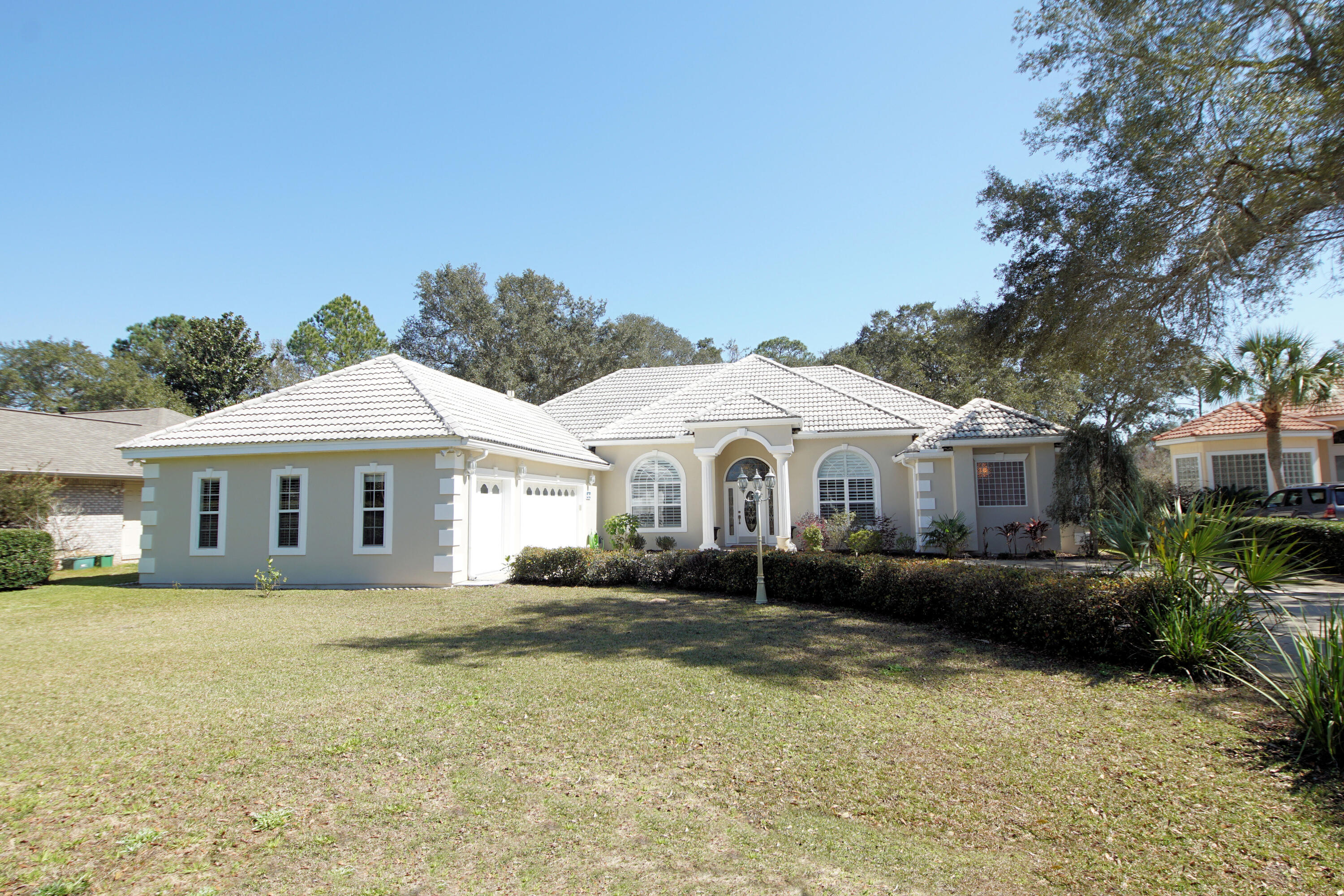Prepare to be impressed with this lovely, Mediterranean-styled home in the exclusive gated neighborhood of Windward in Bluewater Bay. Fresh updates include a new master bathroom with a walk-in shower and jetted tub, lovely 7.5-inch wood plank flooring throughout the living areas, master bedroom, and kitchen. The kitchen features white cabinets, granite countertops, a Wolf range, a wall microwave, and a generous pantry making the kitchen as pretty as it is functional. Located on the 7th hole of the Bay golf course within walking distance to the community beach. Enjoy views of the bay from your private screened patio. Updates include the new HVAC and water heater in 2019, fresh exterior paint, new light fixtures, and an updated sink in the laundry room.