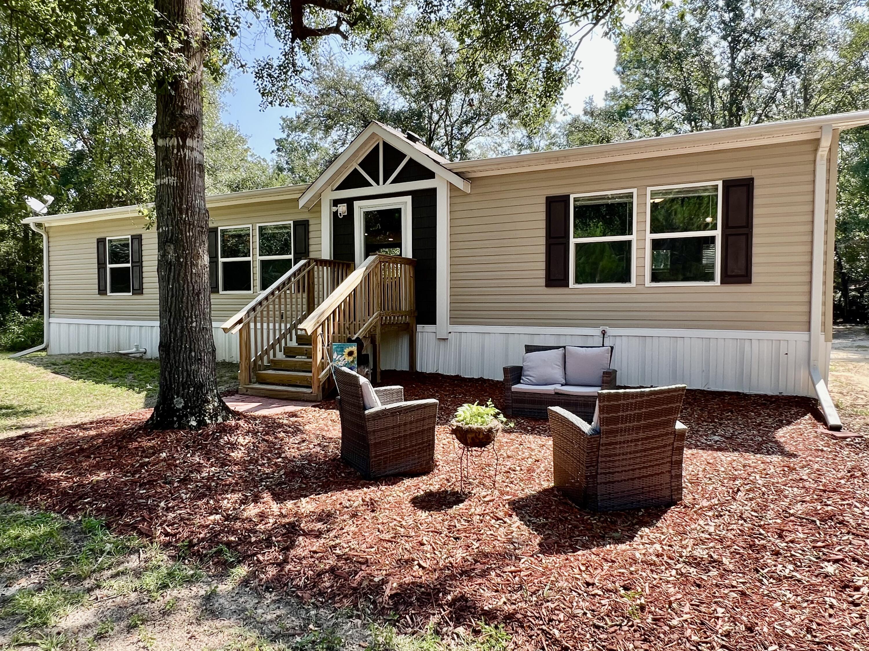 Tucked away on just over 4 secluded acres, this beautifully maintained 3-bedroom, 2-bath home offers peace, privacy, and plenty of extras. A circle driveway welcomes you to the property, which features lush landscaping, a covered carport, RV parking, and multiple outbuildings--including a yard building with power and water. Inside, you'll find a spacious, open layout with vinyl flooring throughout. The kitchen is a standout with a large island--perfect for cooking or serving guests. All bedrooms are generously sized, and the primary suite feels like your own private oasis with a double vanity, large soaking tub, and separate shower. This move-in-ready home is like new and waiting for you to enjoy the quiet life with space to spread out.