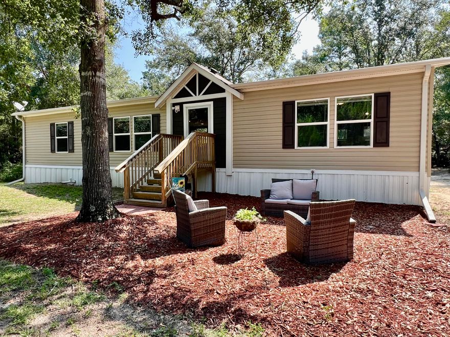 Tucked away on just over 4 secluded acres, this beautifully maintained 3-bedroom, 2-bath home offers peace, privacy, and plenty of extras. A circle driveway welcomes you to the property, which features lush landscaping, a covered carport, RV parking, and multiple outbuildings--including a yard building with power and water. Inside, you'll find a spacious, open layout with vinyl flooring throughout. The kitchen is a standout with a large island--perfect for cooking or serving guests. All bedrooms are generously sized, and the primary suite feels like your own private oasis with a double vanity, large soaking tub, and separate shower. This move-in-ready home is like new and waiting for you to enjoy the quiet life with space to spread out.