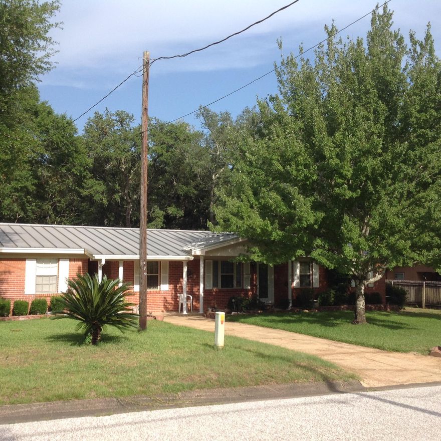 Remarkable brick home for a pool lover's paradise! Relax in an enclosed, in-ground heated pool all year round! Pool area is laid with pavers that leads into the screened porch complete with a gas grill. Observe nature with a large open deck connected to pool house. Hear the small stream trickling or the birds chirping in the wooded area around you. Enjoy the benefits of a long, shaded driveway leading up to a spacious carport equipped with a workshop! Metal standing seam roof installed in 2004 to help keep the home cool during the summer. Put your mind at ease during the hurricane season with a gas whole house generator. Need a place to store your classic car? Use a detached 2 story 16X24 metal workshop with a one car garage roll up door. Energy efficient with a touch of classic!