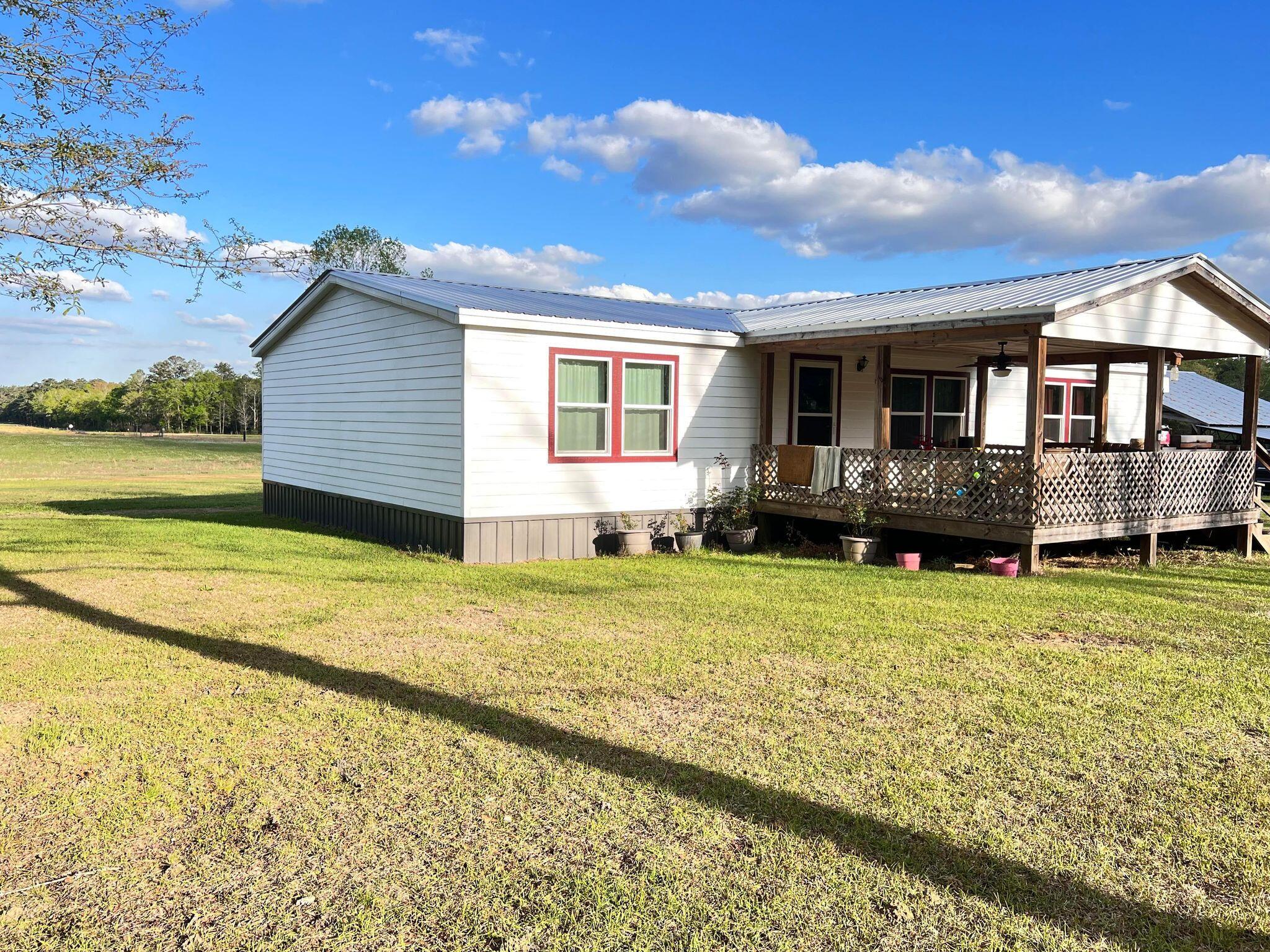This well maintained 3 bedroom, 2 bath home is situated on 40 acres. Roughly 20 acres are cleared. Home sits well off the main road for added privacy. New roof, siding, & skirting, windows installed in 2021. Property offers a 60X40 Pole Barn, 2 utility sheds equipped with electricity, & an additional shed for storage. There is also a building that was used as an office. It offers a 1/2 bath with septic, power, & split wall AC/Heater unit. Property as an additional septic, well, and power hook up that was installed in 2017.